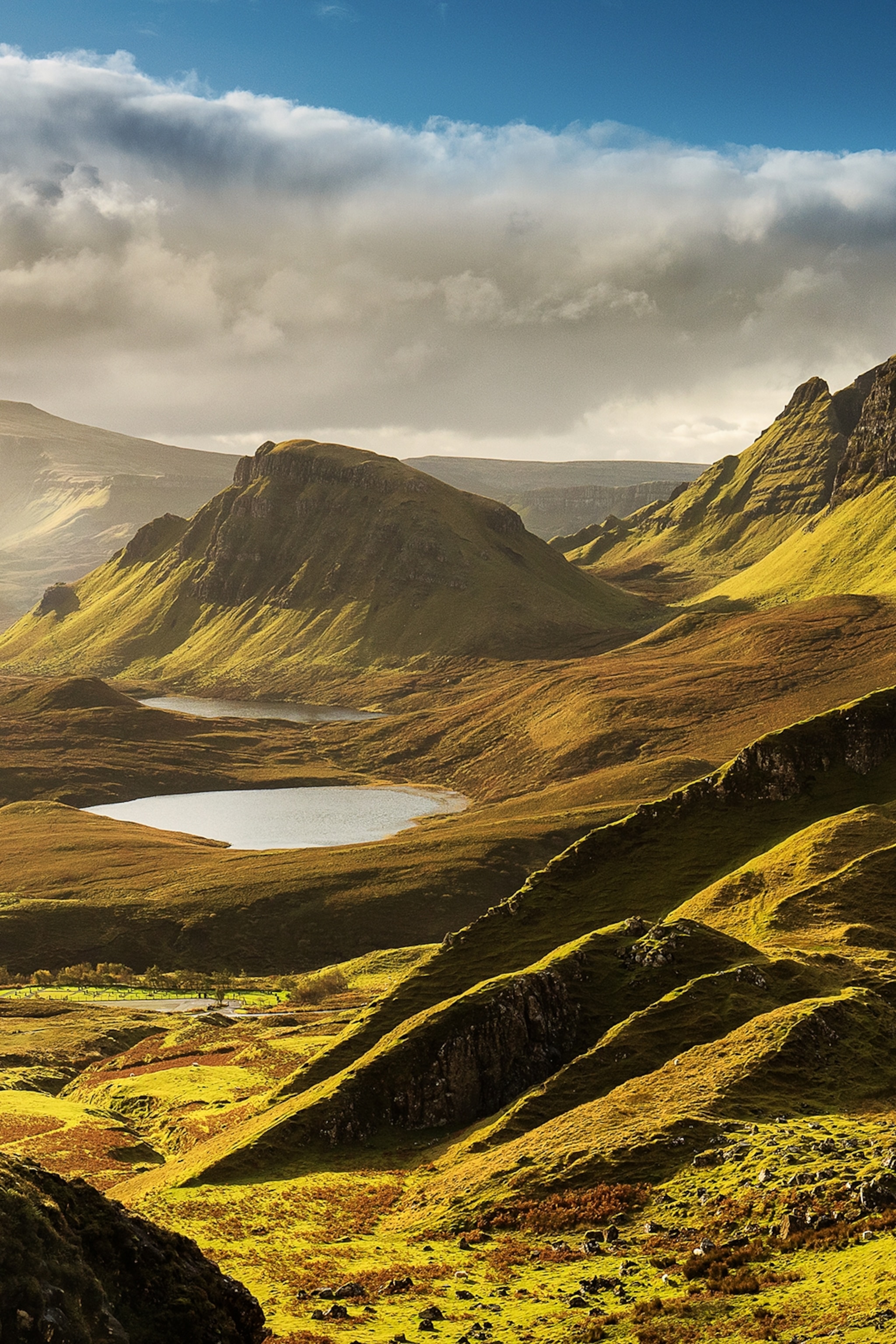 A grassy valley with hills and mountain lochs on the Isle of Skye.