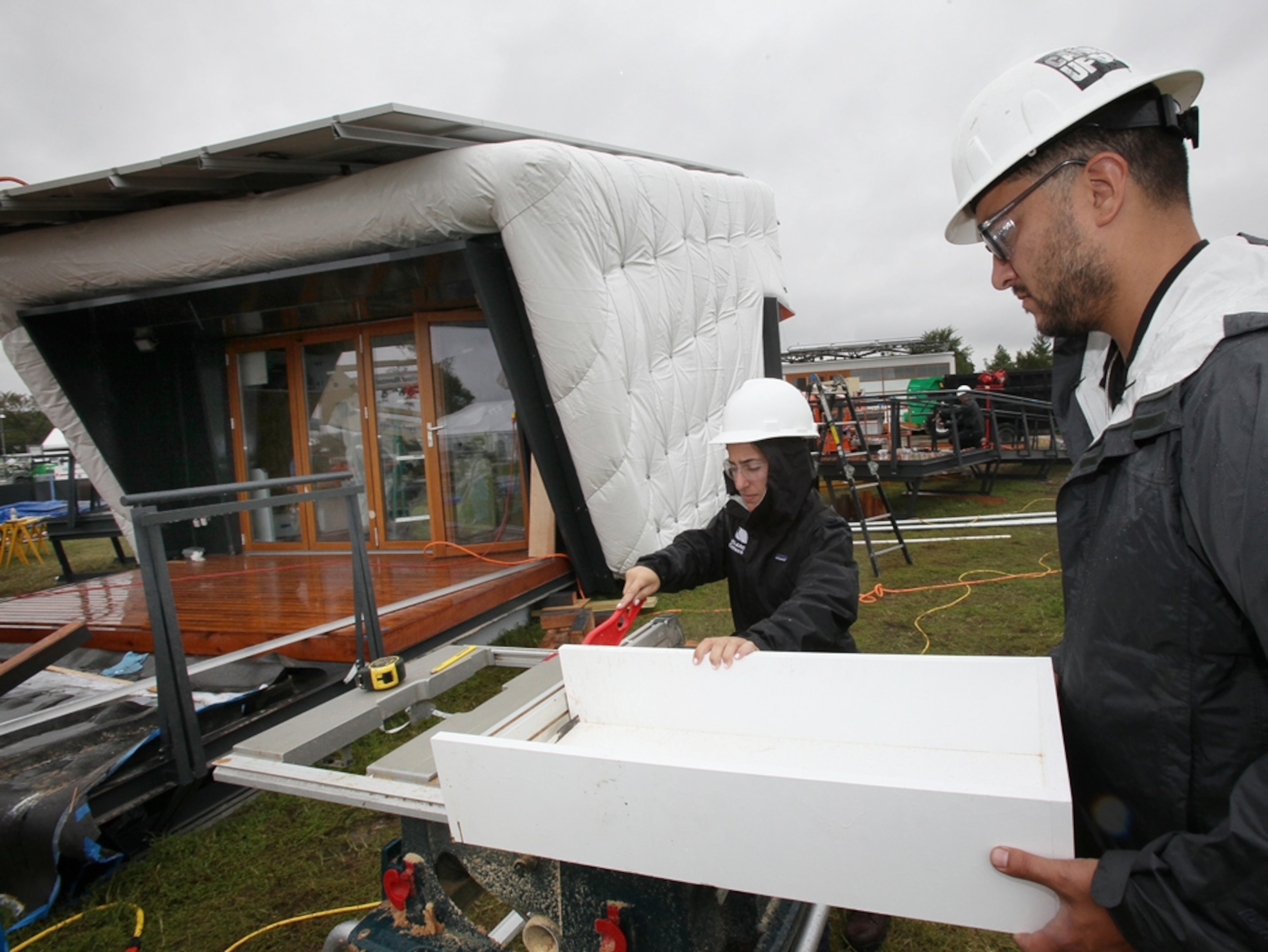 Solar Decathlon contestants cut cabinets for their house.