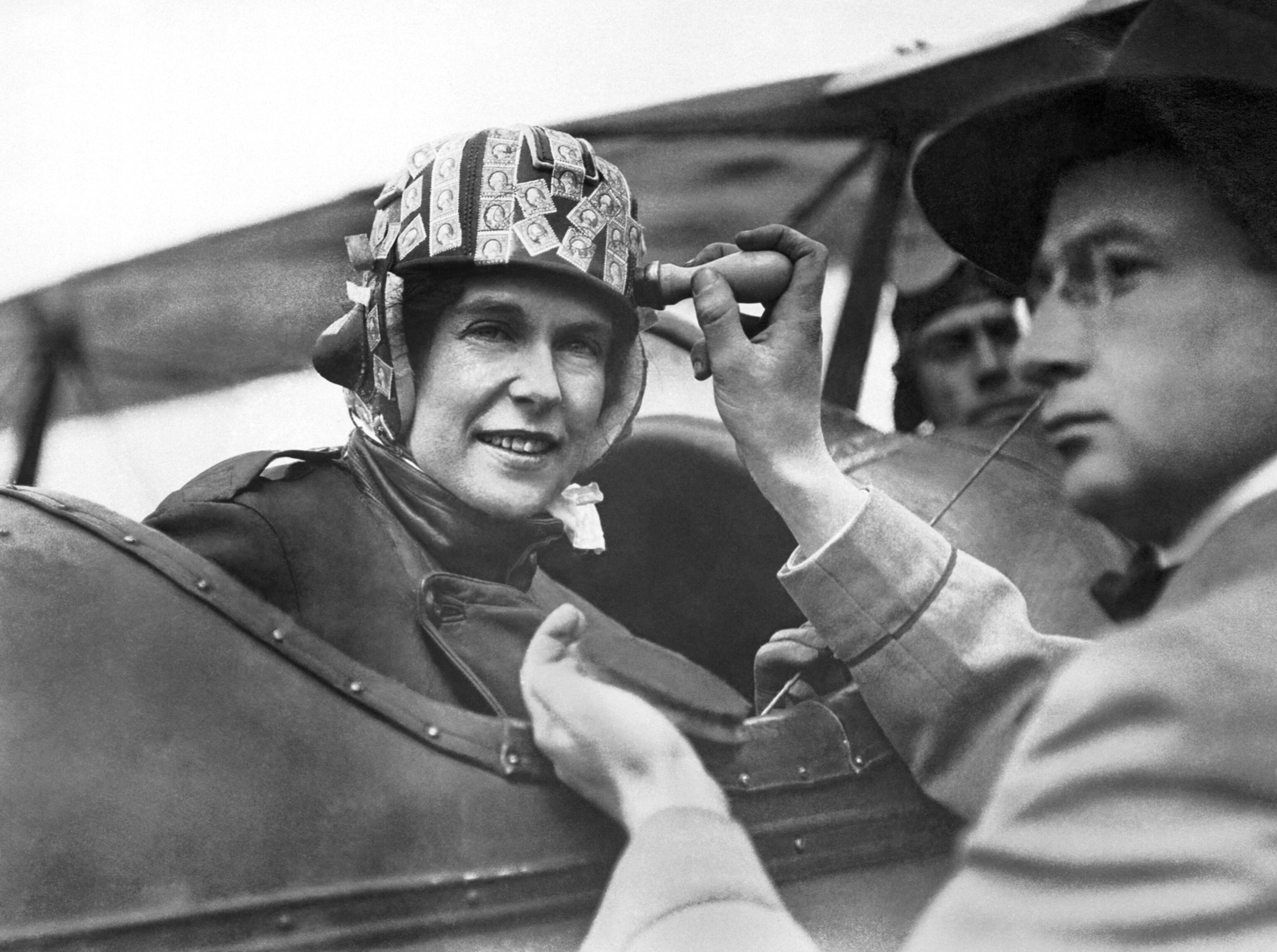 a woman sitting in a plane with stamps on her helmet