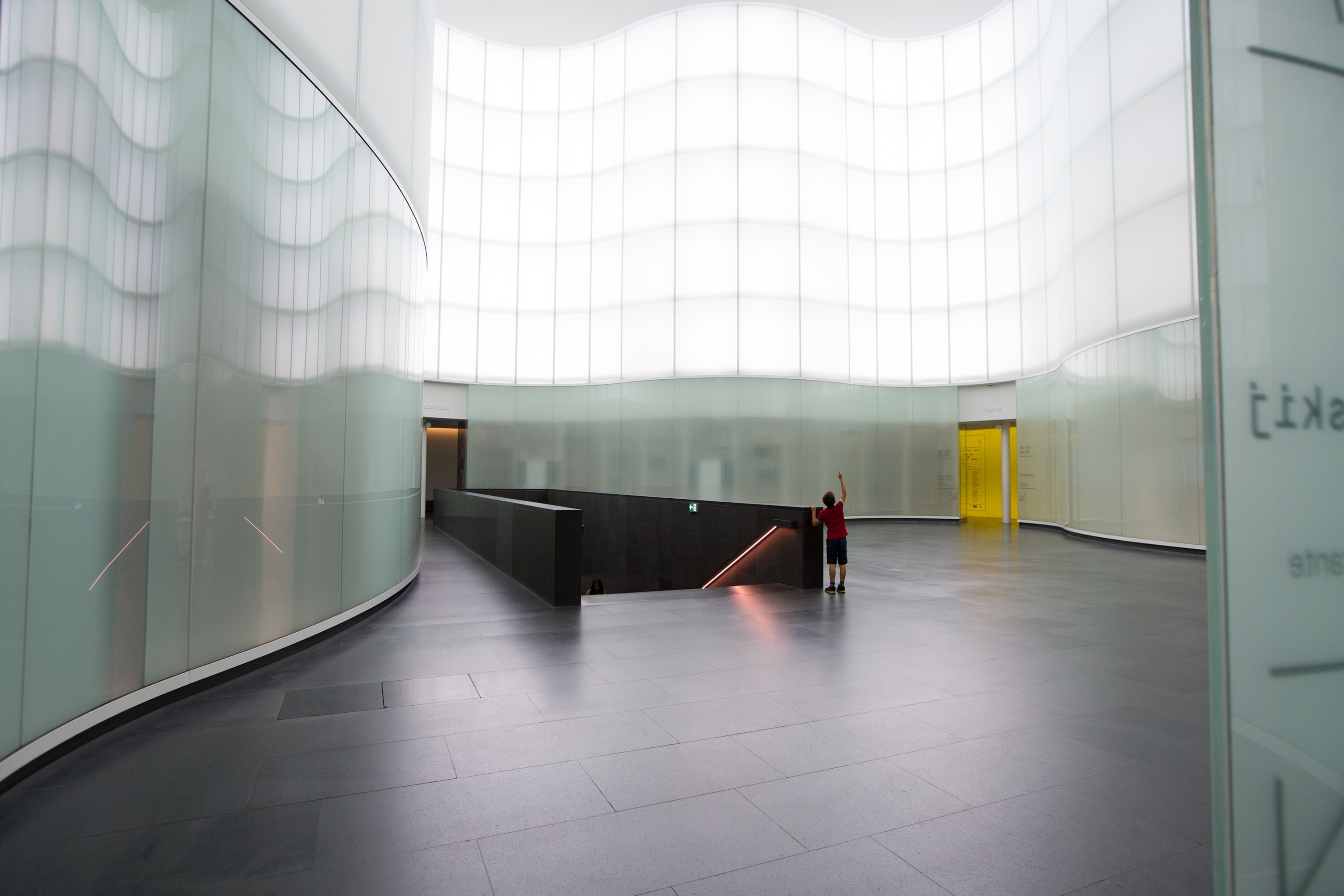 a visitor in the entrance hall of the Mudec museum in Milan, Italy