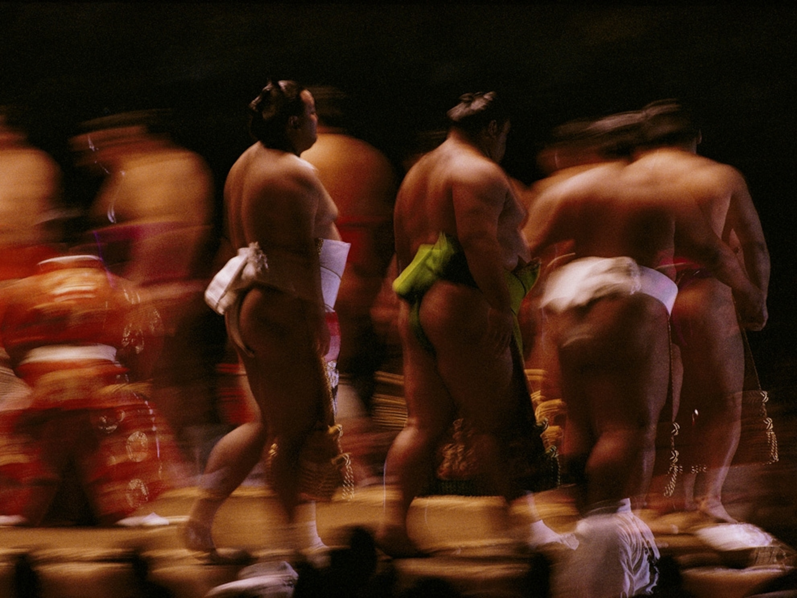 Blurred image of sumo wrestlers in a row
