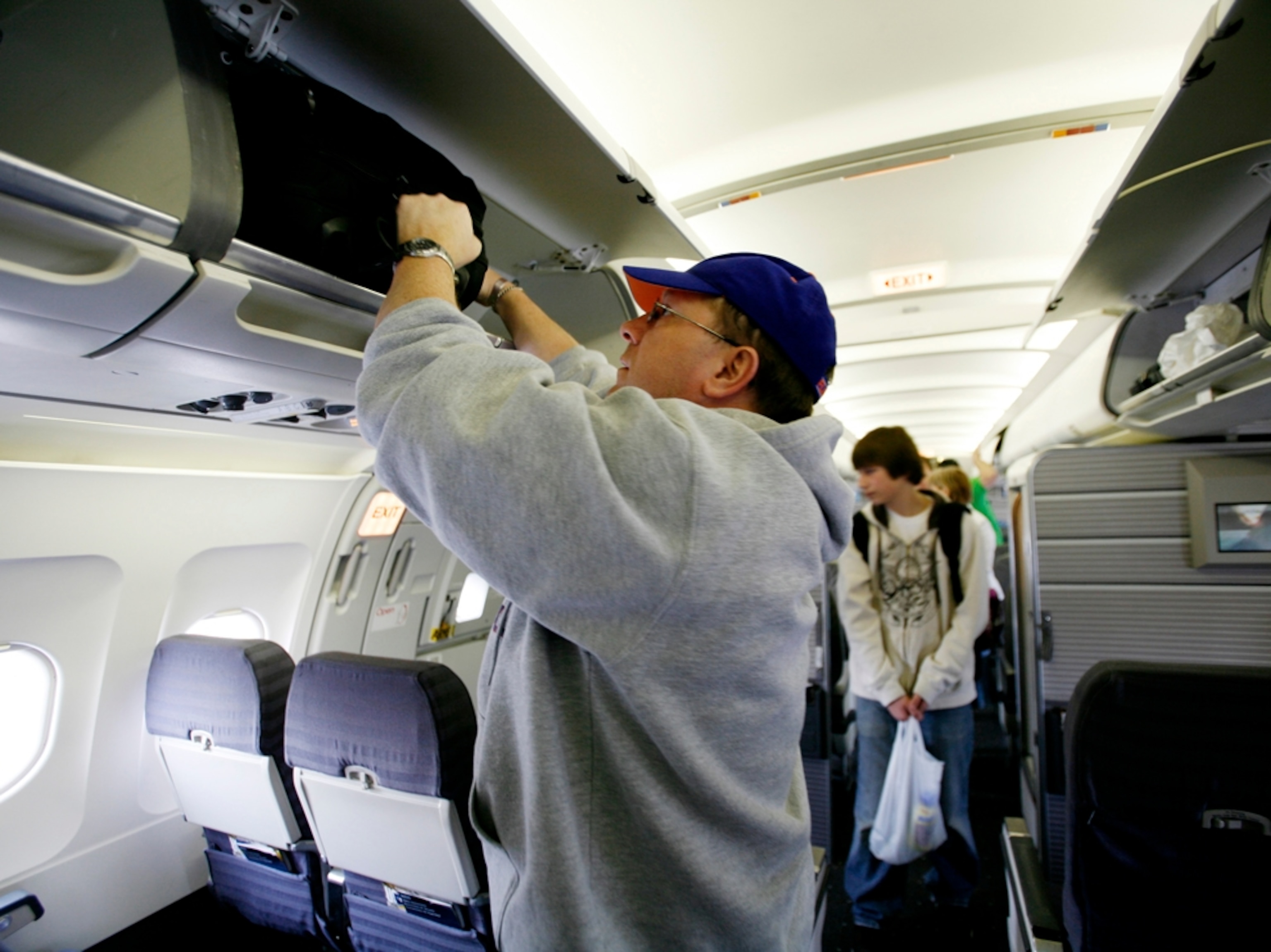 Airline passenger stowing bag