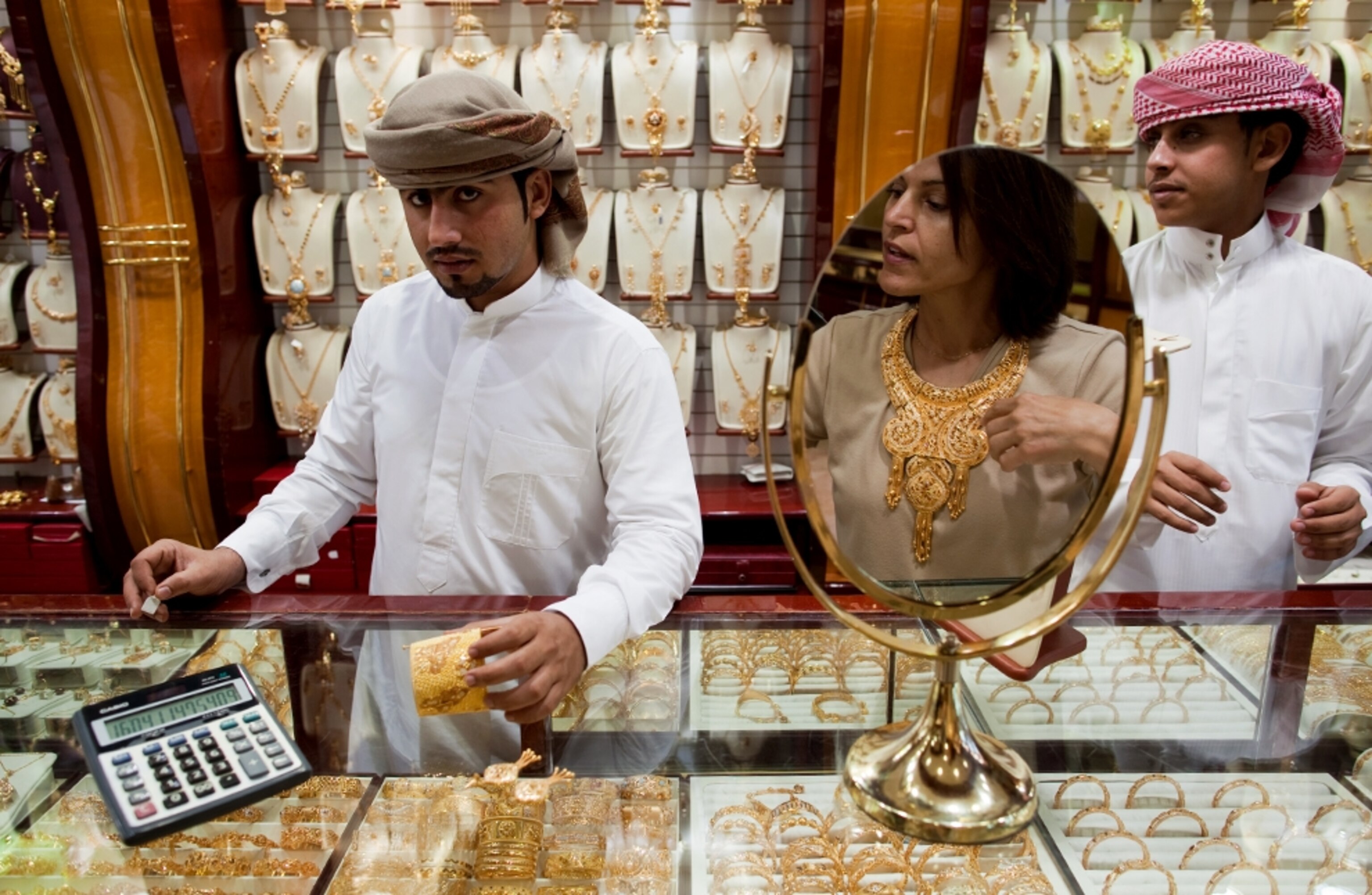 Woman trying on gold jewelry for sale (photo)
