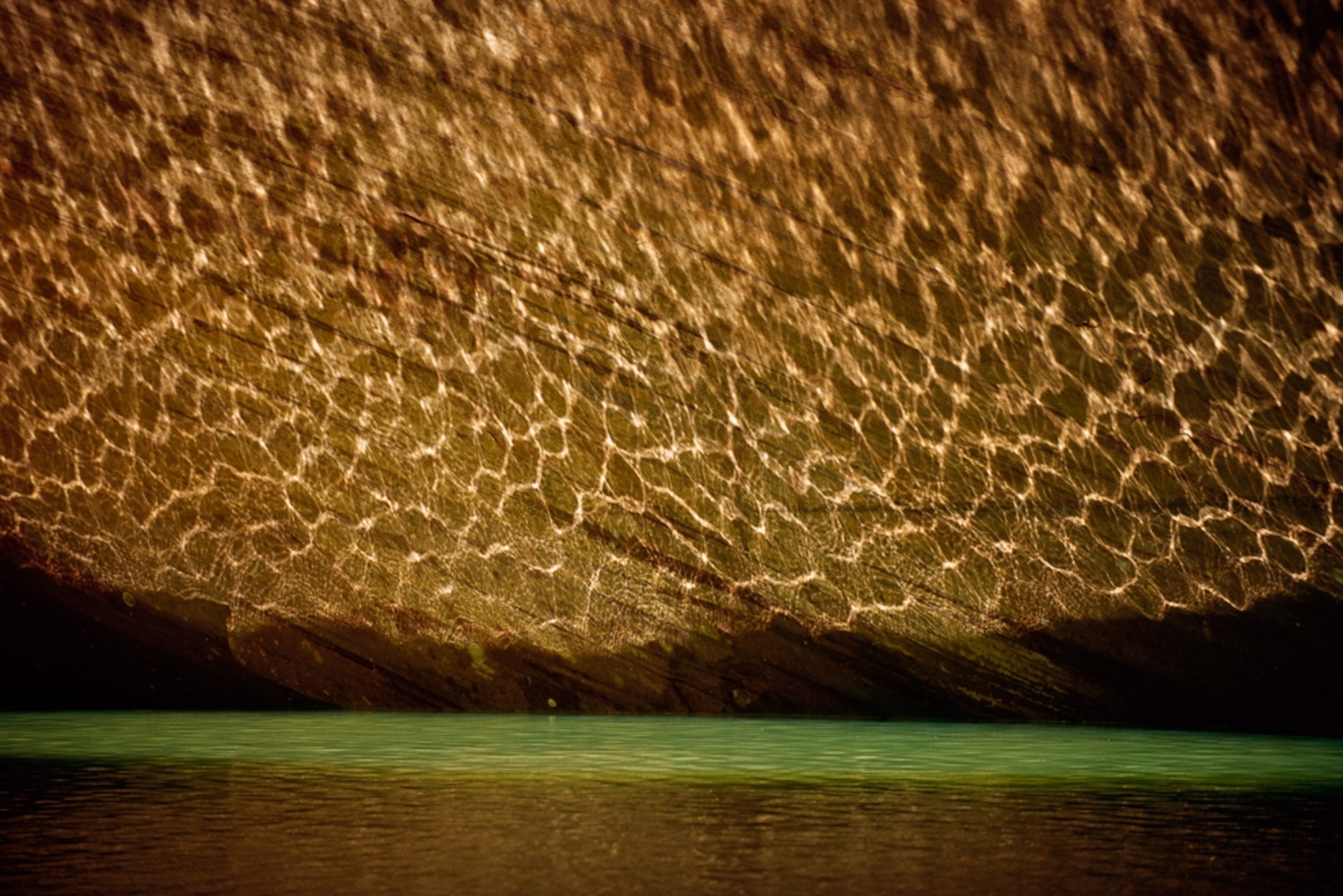 light patterns reflecting off water onto a rock wall, Utah