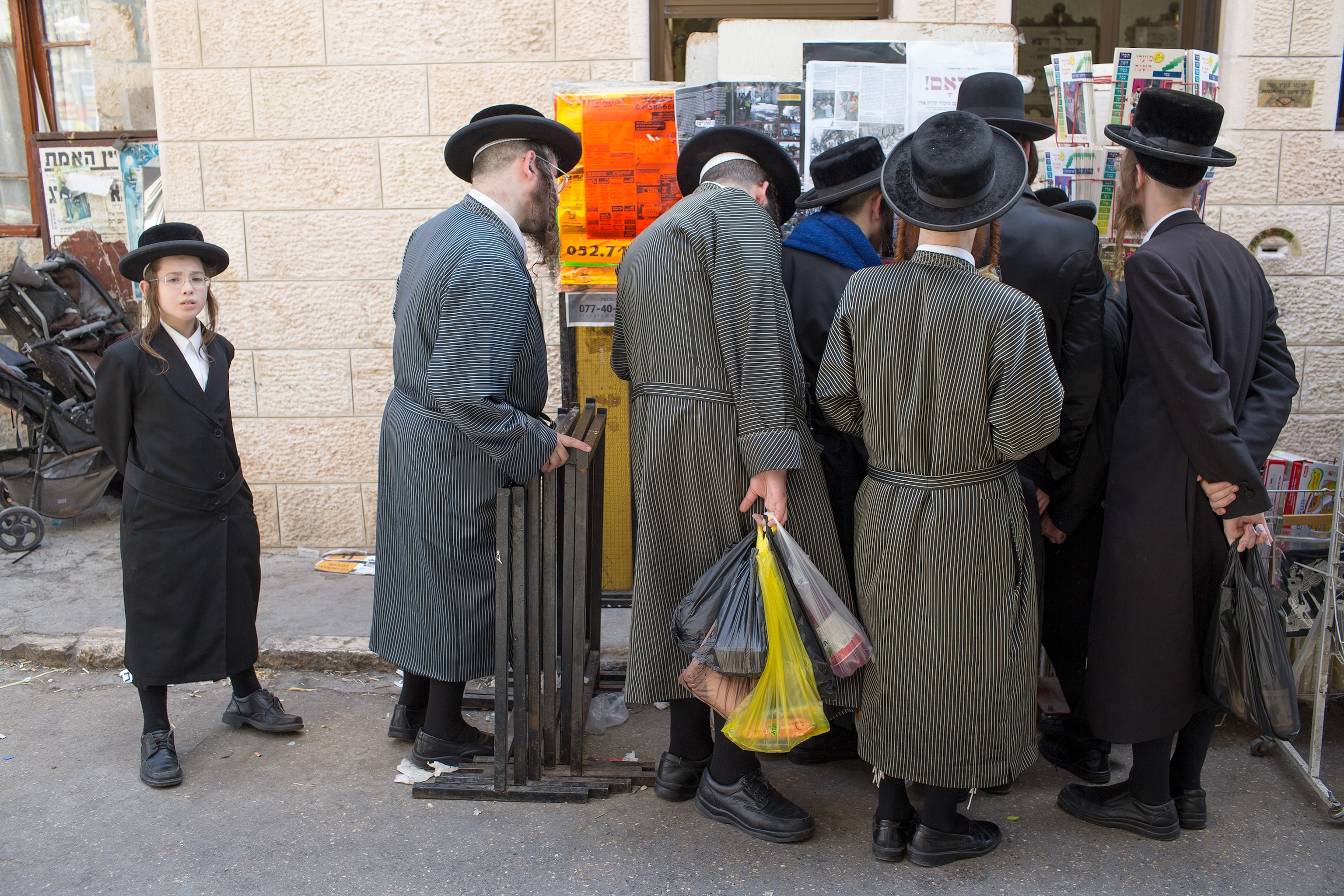 Ultra Orthodox Jewish men reading the street wallpaper in Jerusalem, Israel