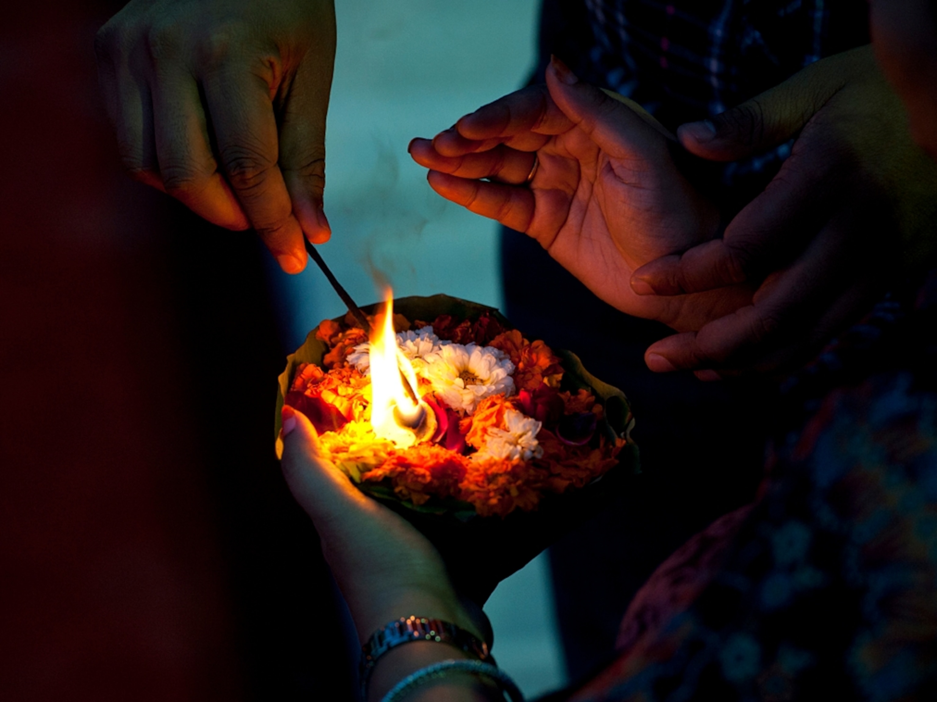 Lighting a flame in flower filled bowl