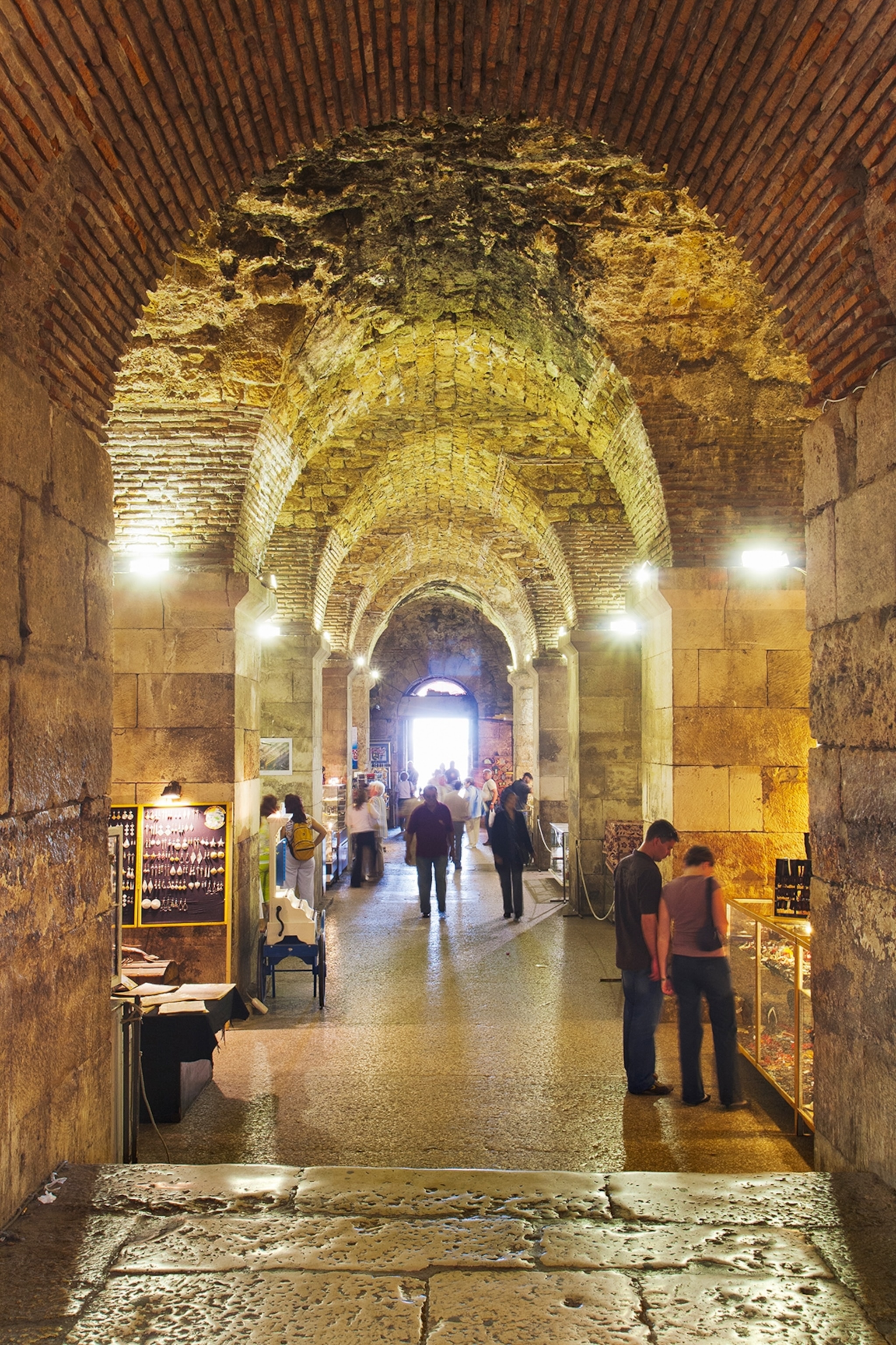A cave-like tunnel with arches and craft shops on either side.