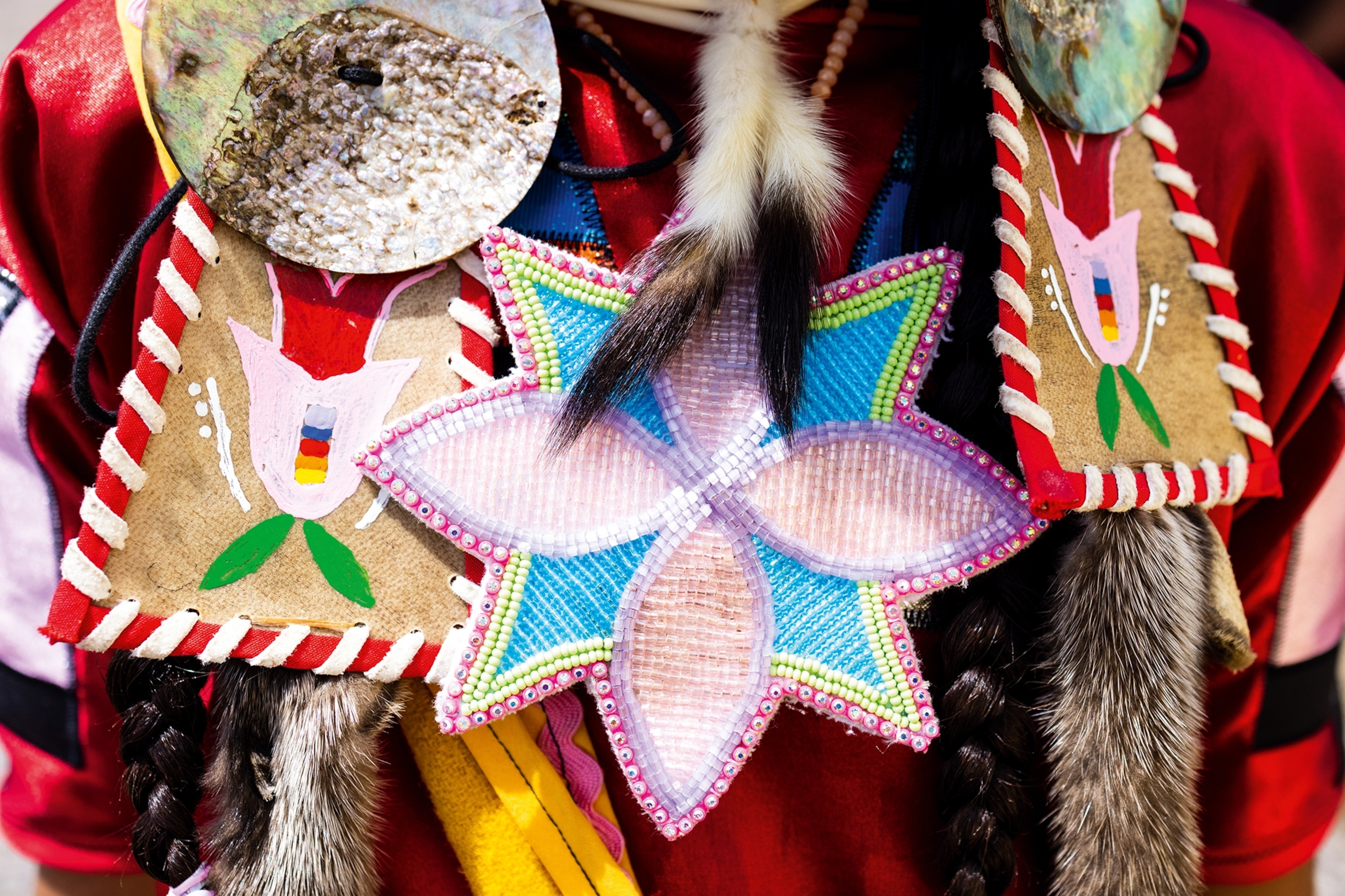 A detail shot of beaded flowers, decorated leather lapels and animal fur tails.