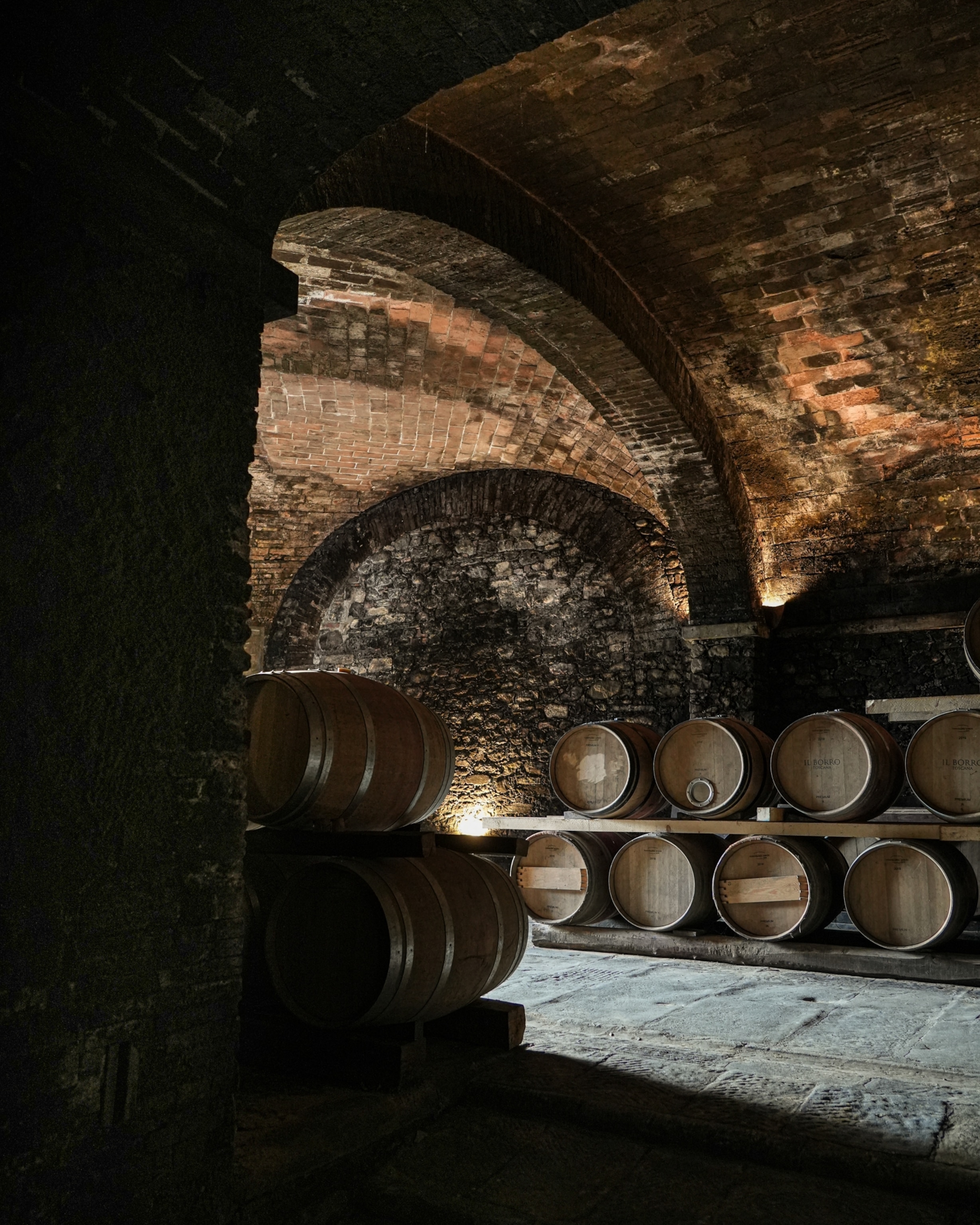 Wooden wine barrels stacked in a large wine cellar in the Il Borro Toscana hotel.