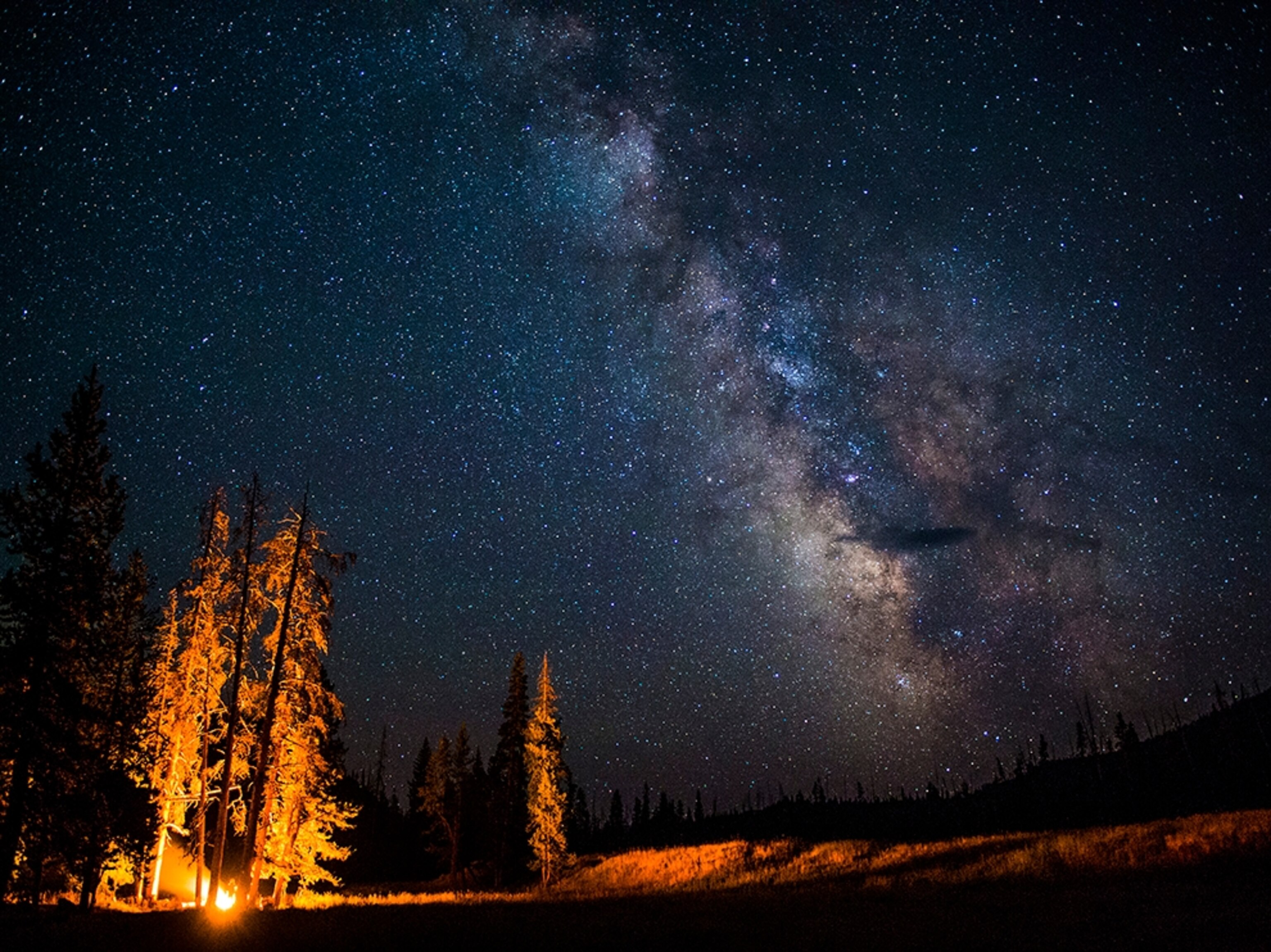 a campsite with the Milky Way hovering above it.