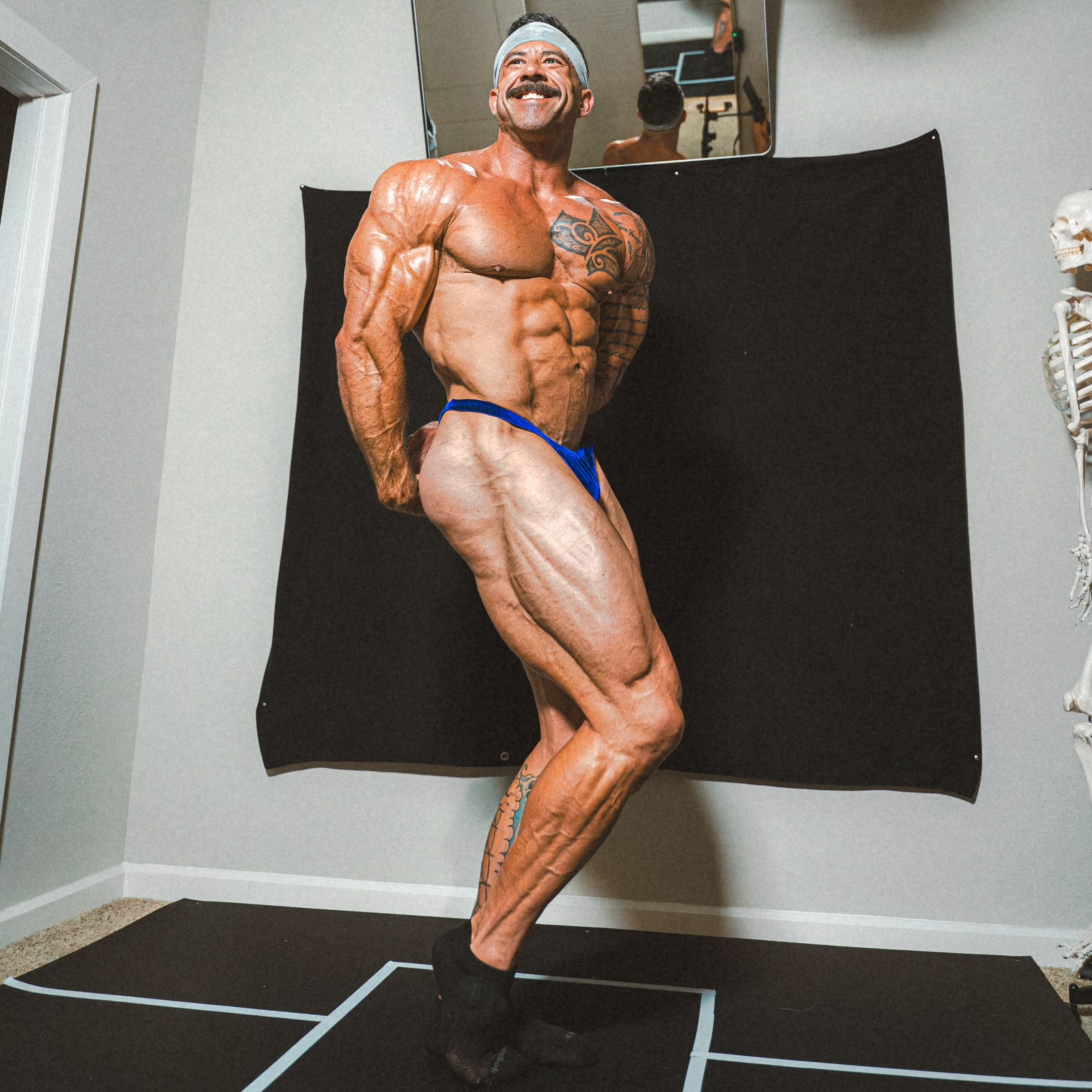 Daniel Coffeen smiling as he flexes his muscles