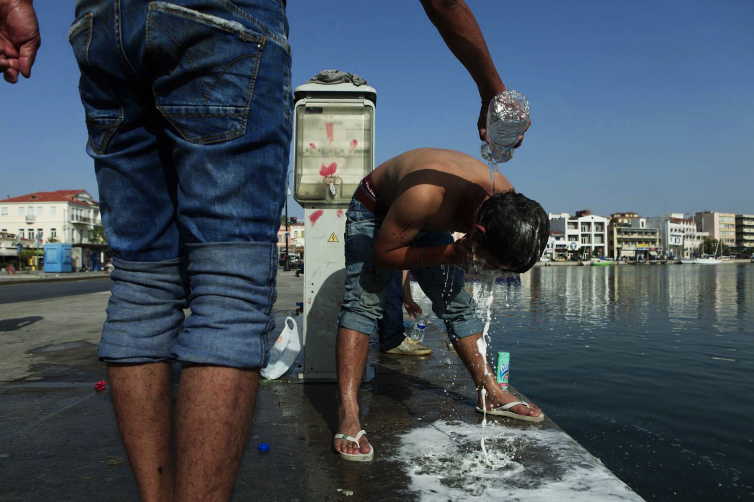 Hazara refugees from Afghanistan washing before heading to the port of Mytilini