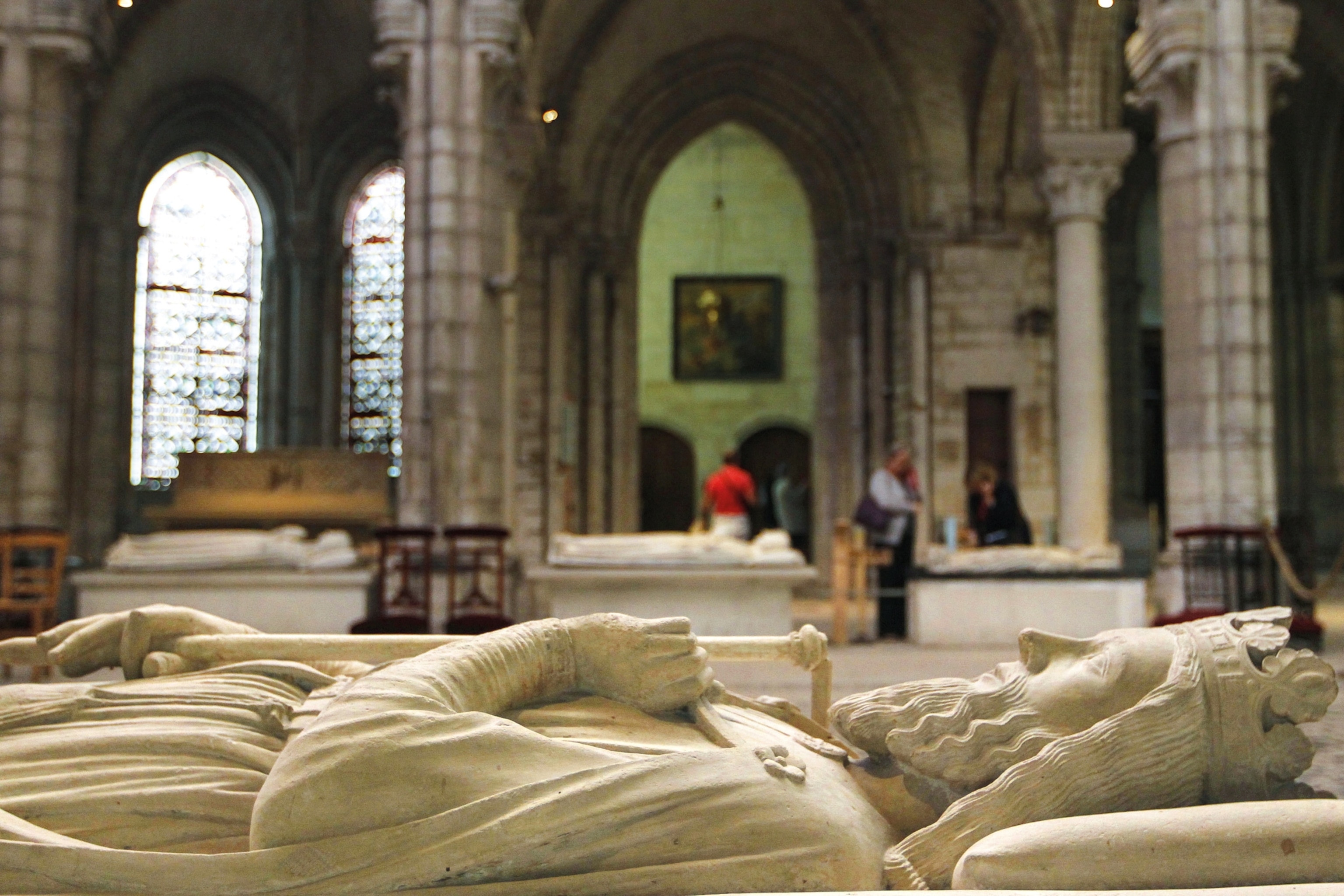 A statue of a man wearing a crown laying down