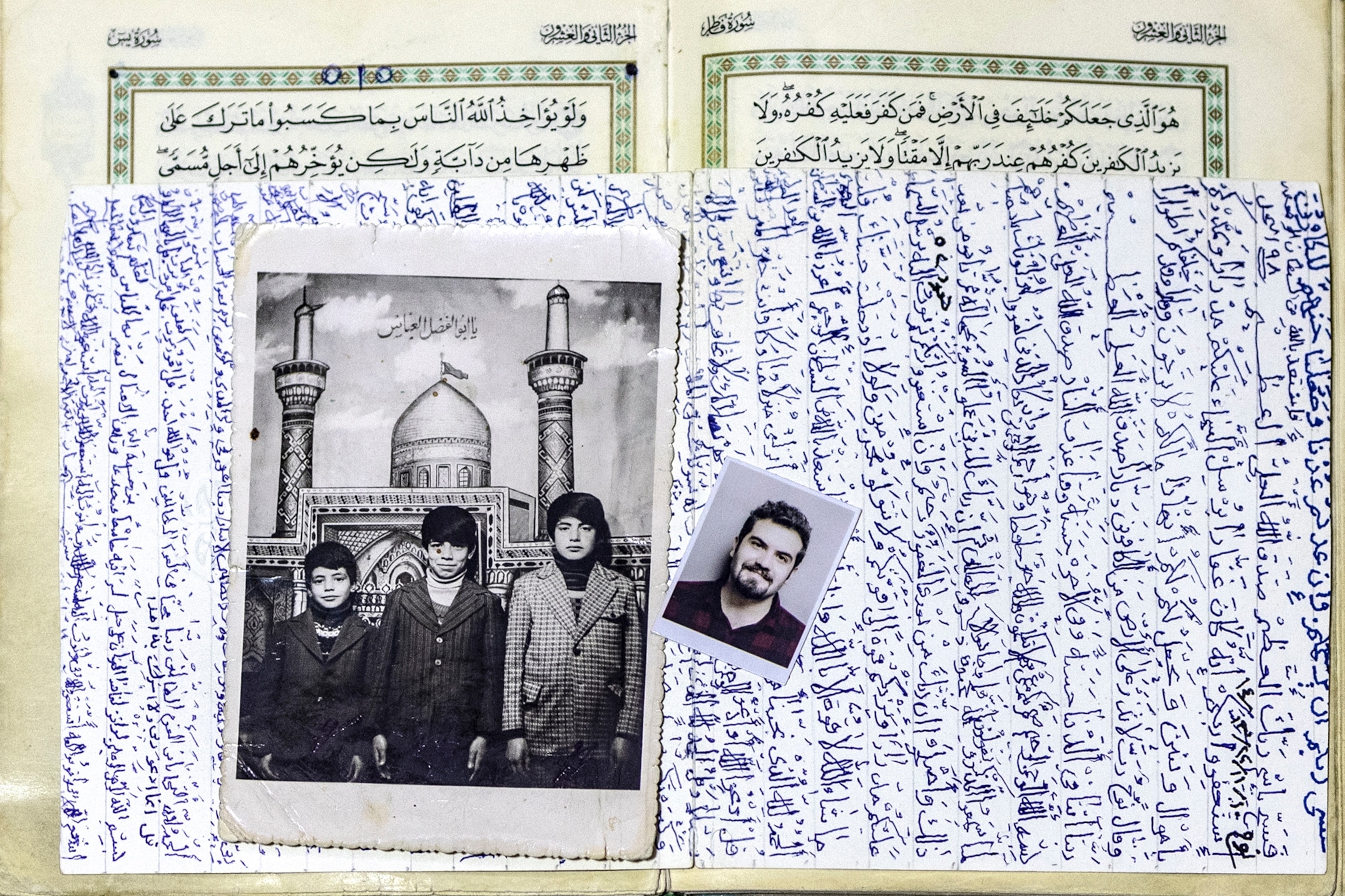 Two black and white photos lay on top of an open Quran