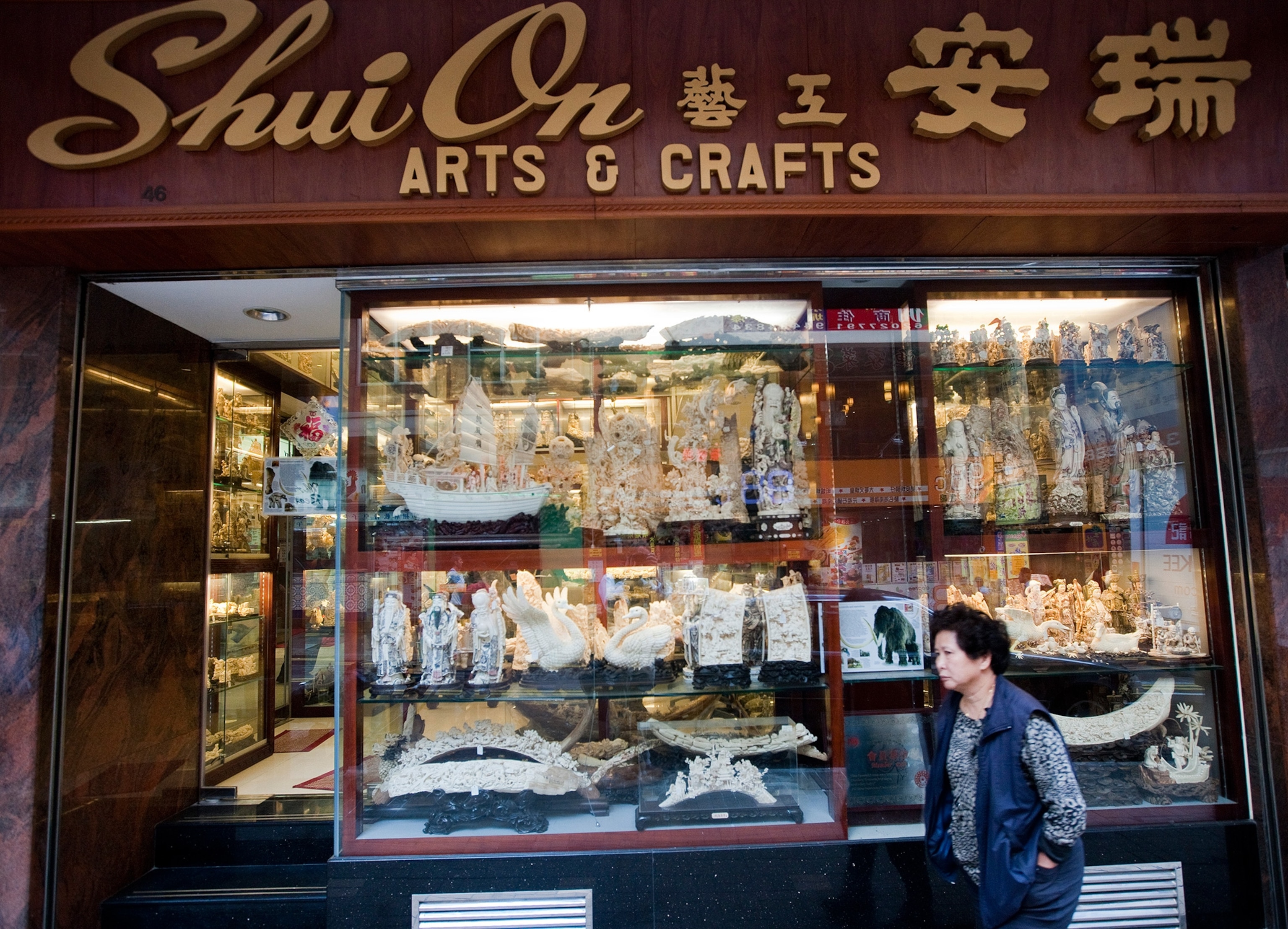 pedestrian walking past ivory shop in Hong Kong
