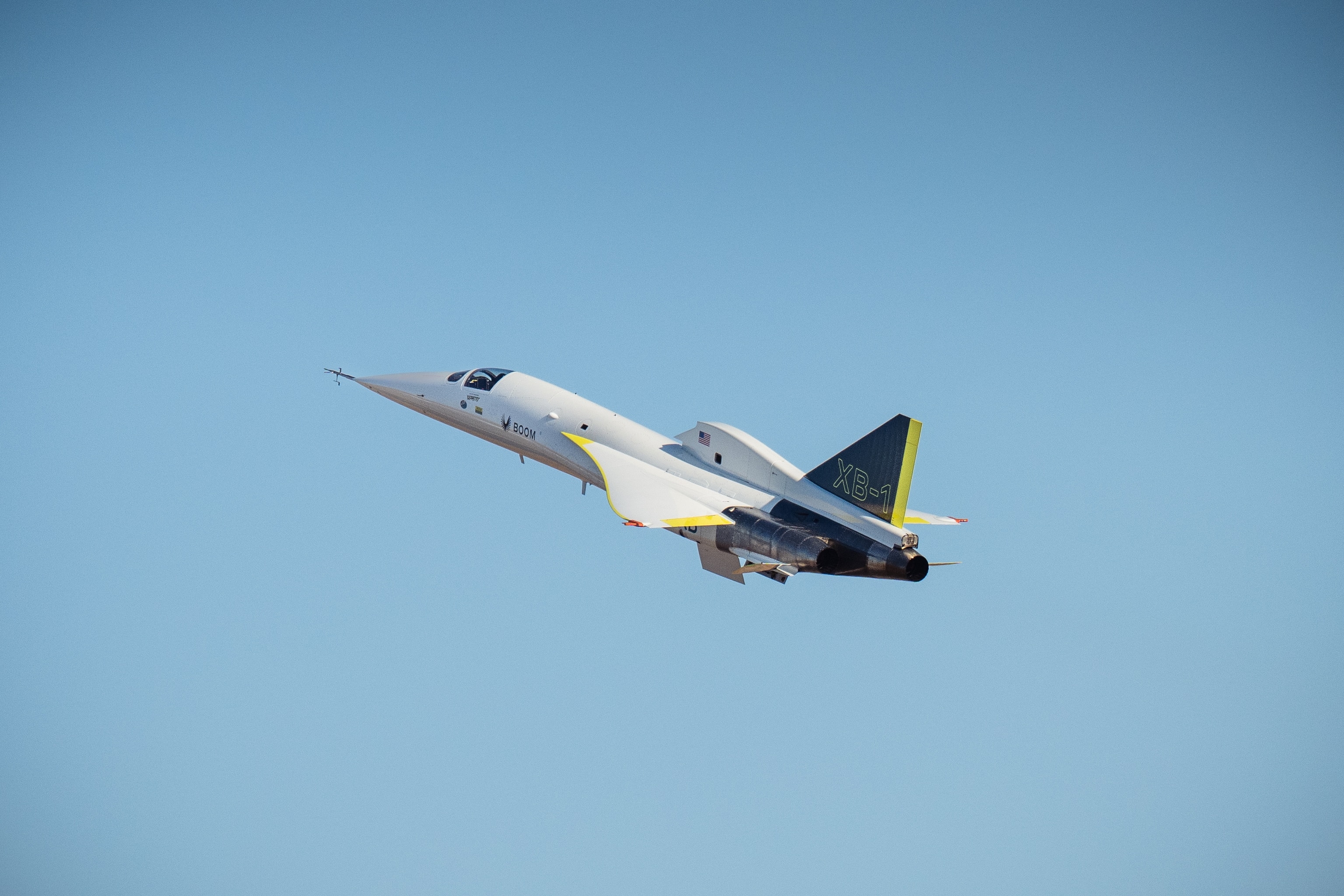 A jet with "XB-1" written on the wing flies in the sky