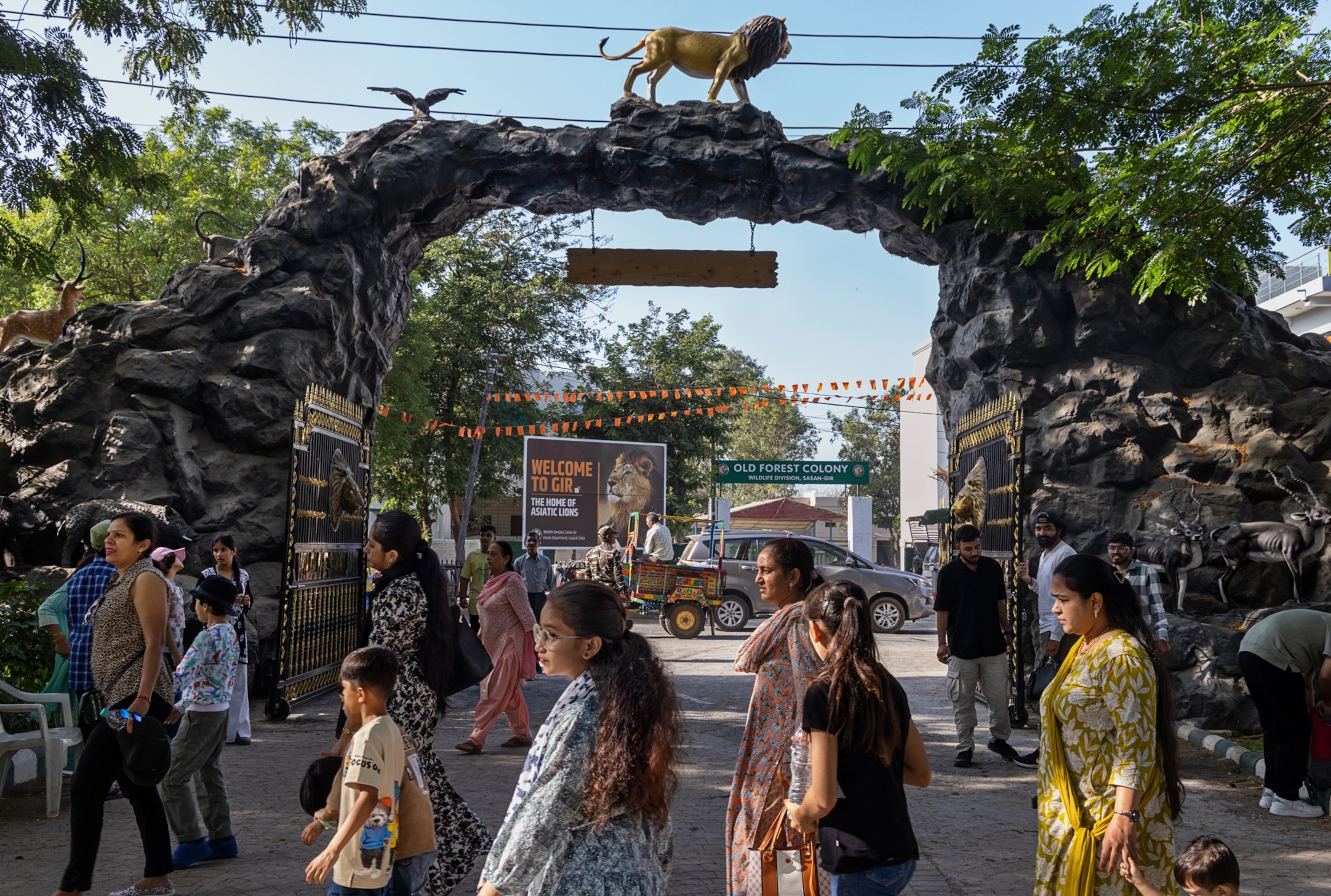 People walk in front of an entrance to a Park.