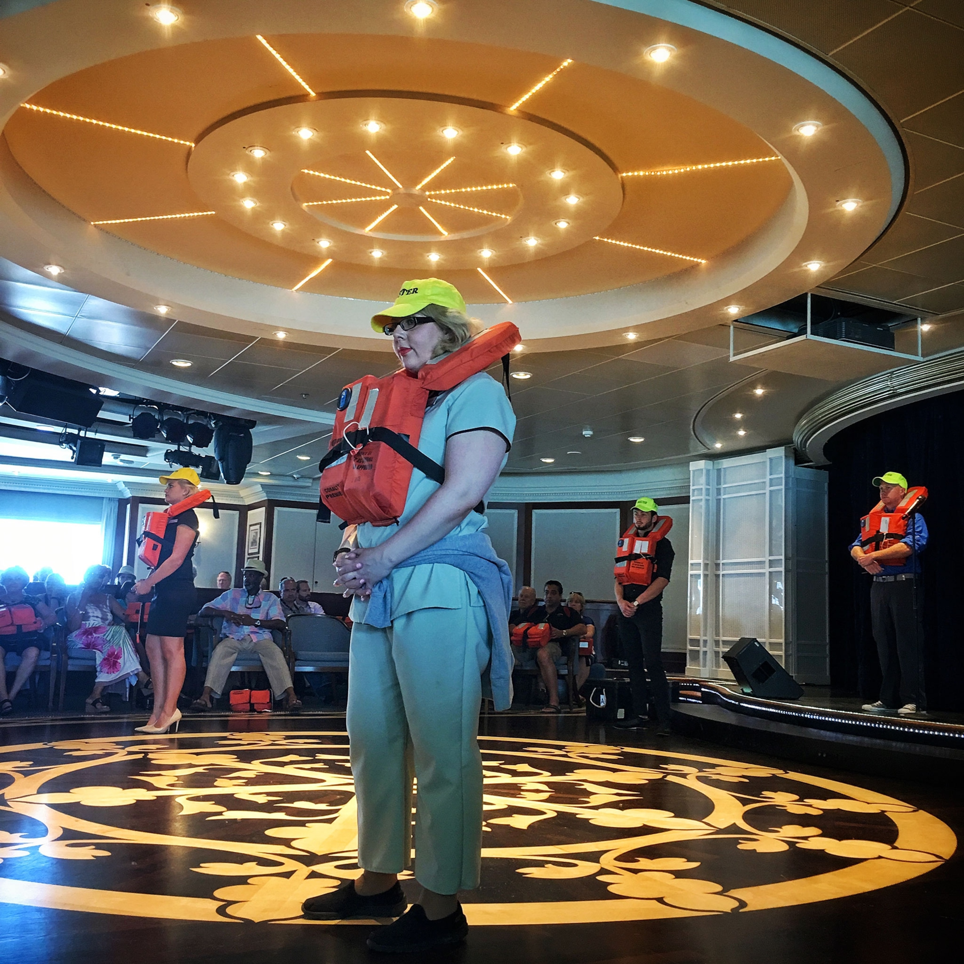 passengers on a cruise ship wearing life jackets