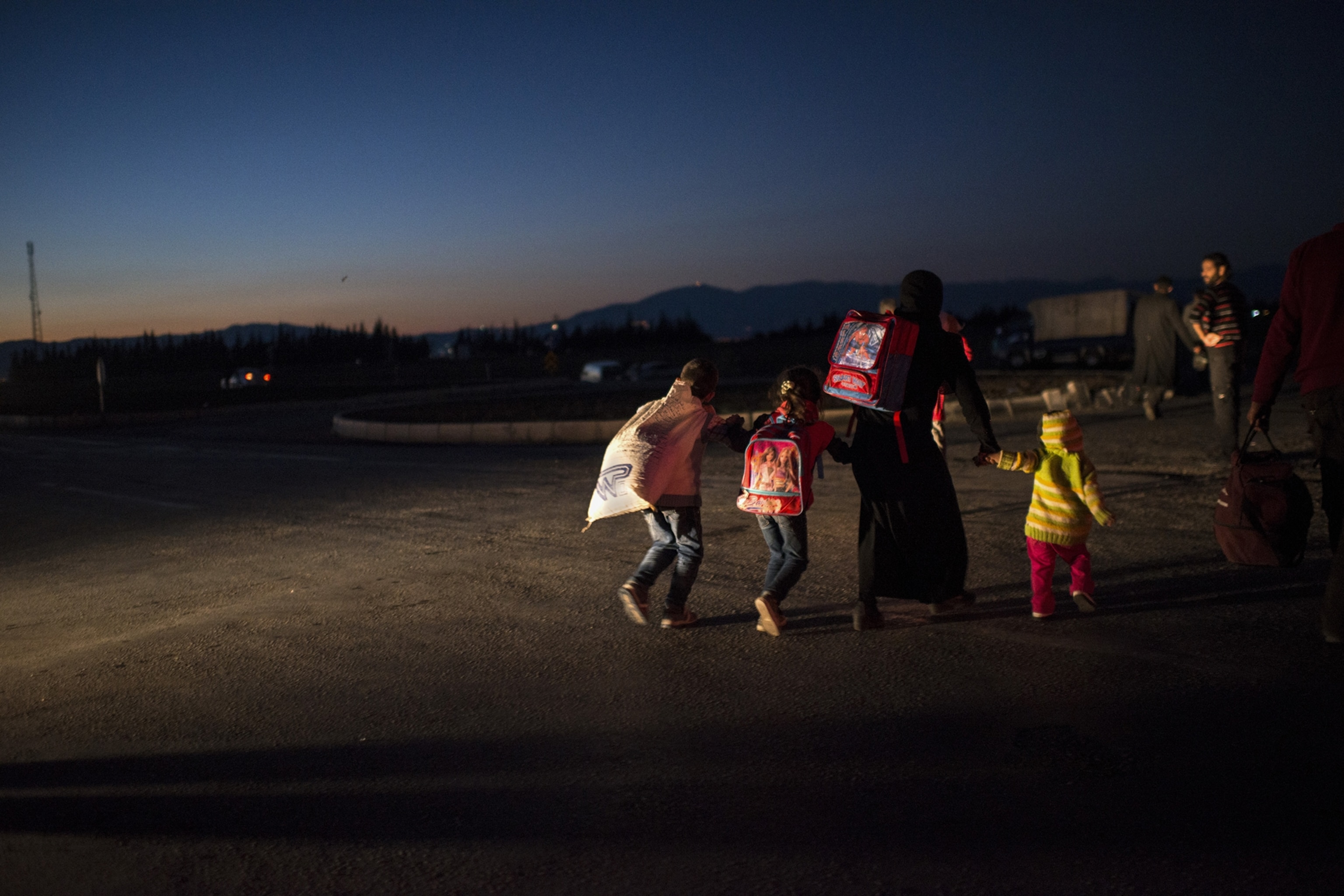 Syrian refugees cross into Turkey after the Muslim Holiday of Eid al-Adha through unofficial border crossings in villages around Reyhanli and Hacipasa in Turkey, October 20, 2013.