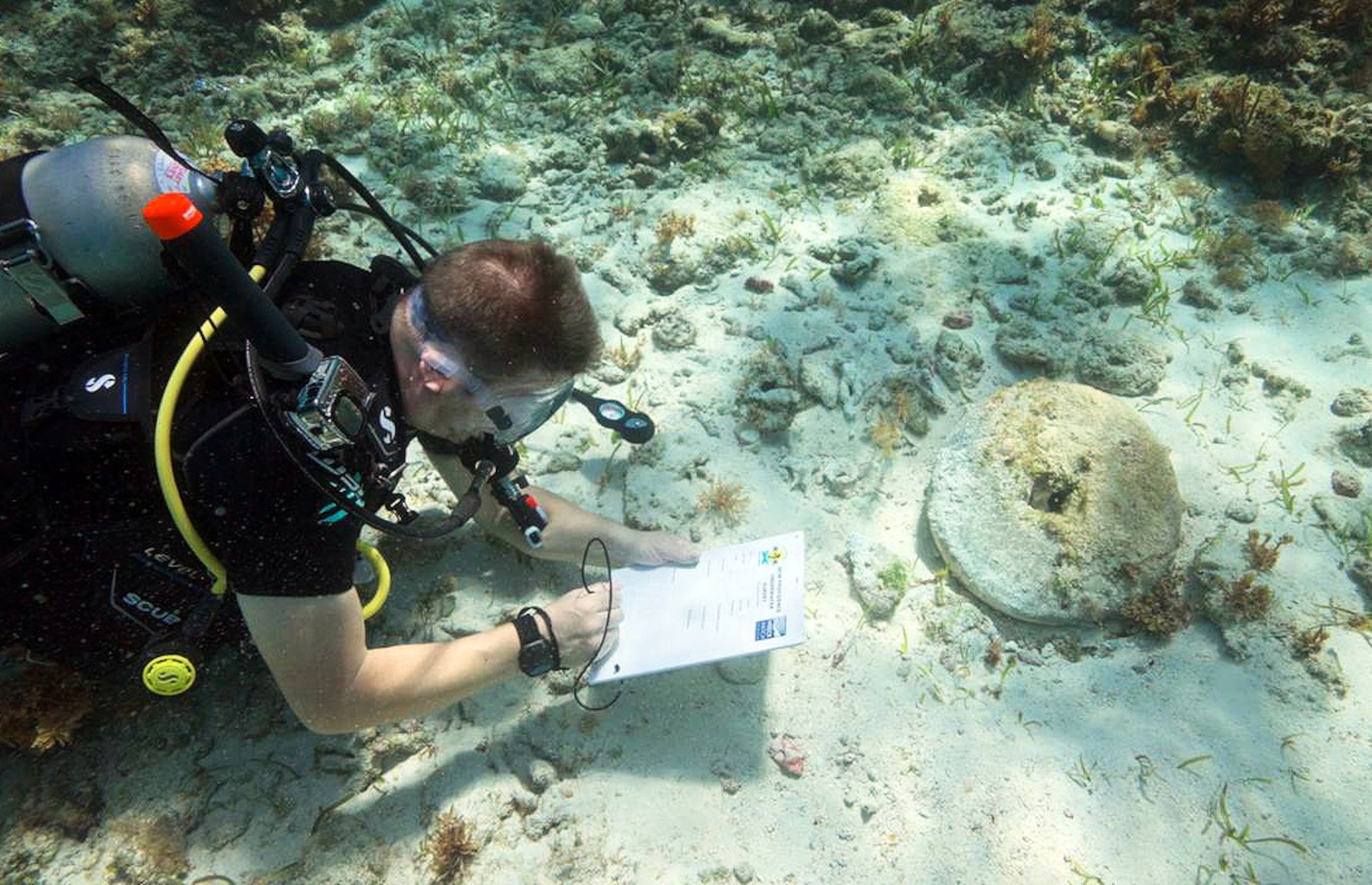 Sean Kingsley records a grinding stone for sharpening swords on an 18th-century shipwreck from the golden age of piracy, east of Nassau harbour, The Bahamas.