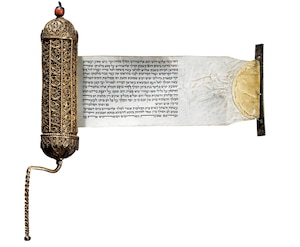 The 19th-century scroll of Esther is pictured unrolled out of a metal canister.
