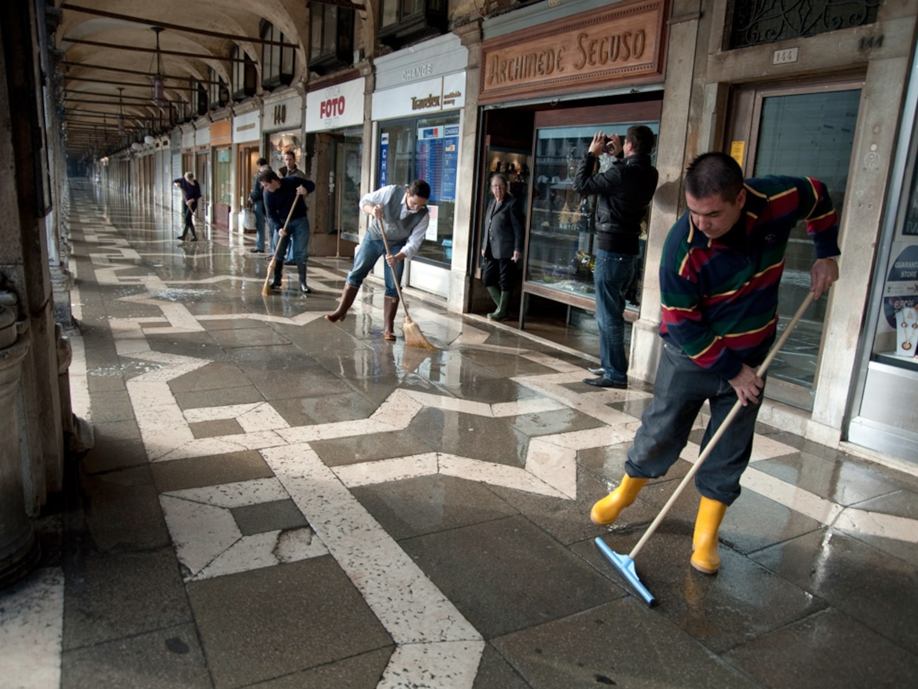 Workers sweeping floodwaters from a plaza