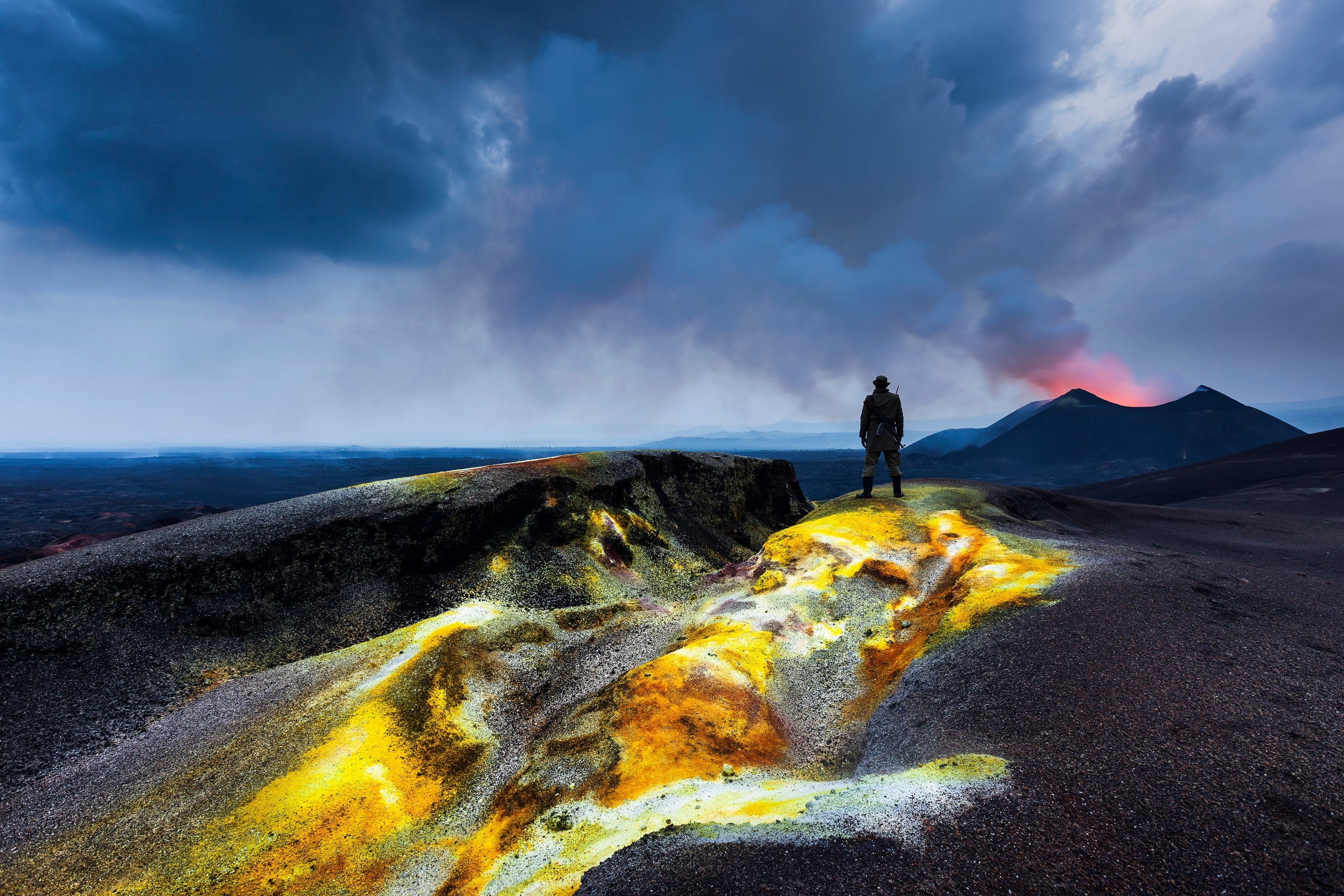 Land covered in bright yellow with a silhouette of a ranger in the distance