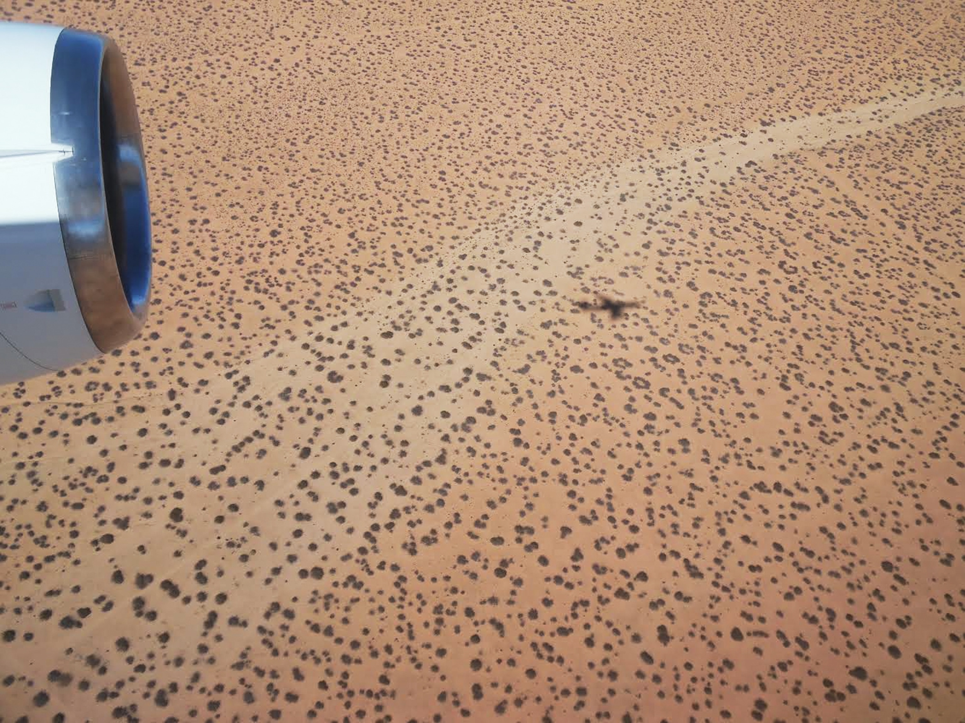 a DC-8 research aircraft casting its shadow on the ground in California's Mojave Desert.