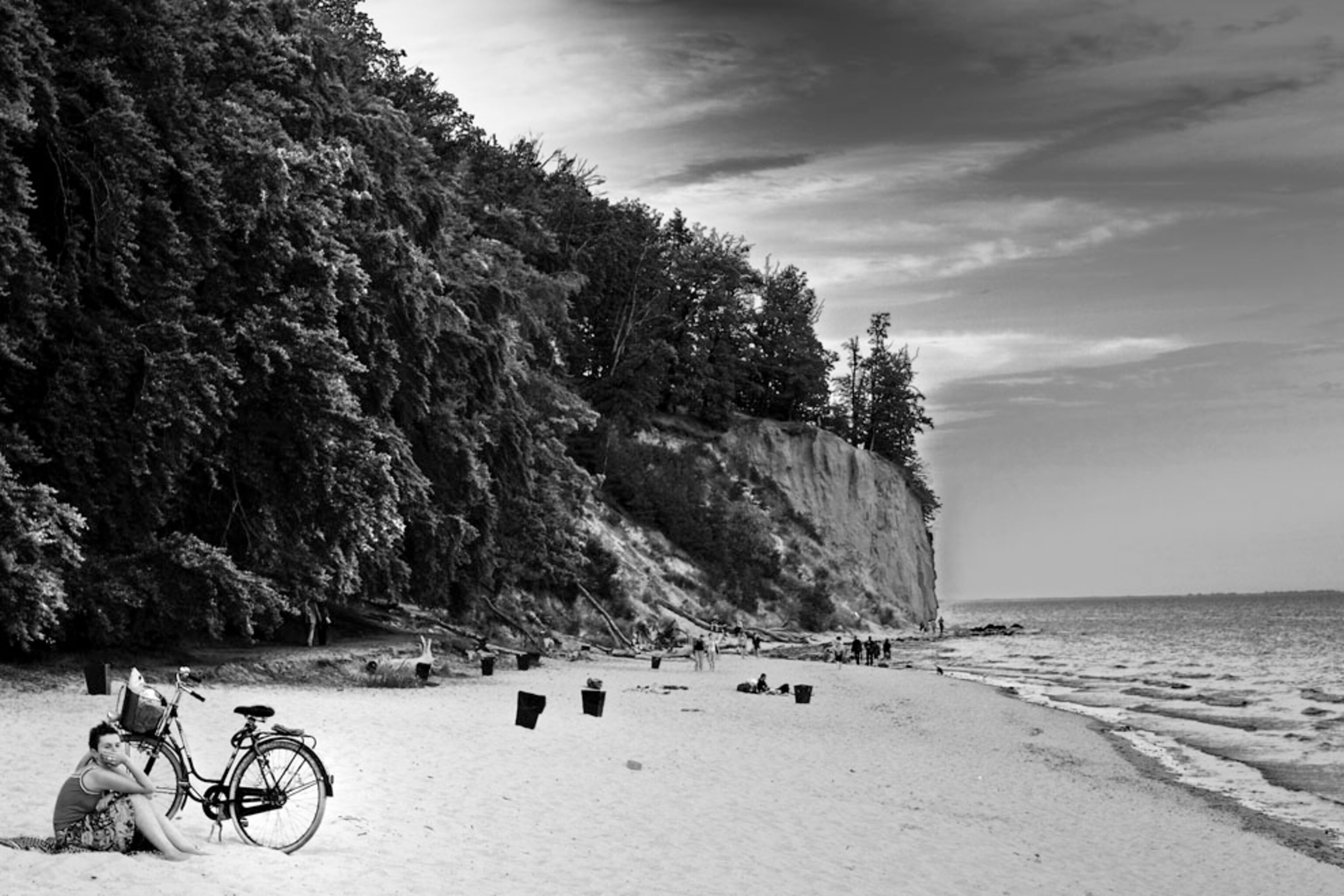 A woman sitting on the beach near a bike in Gdynia, Poland