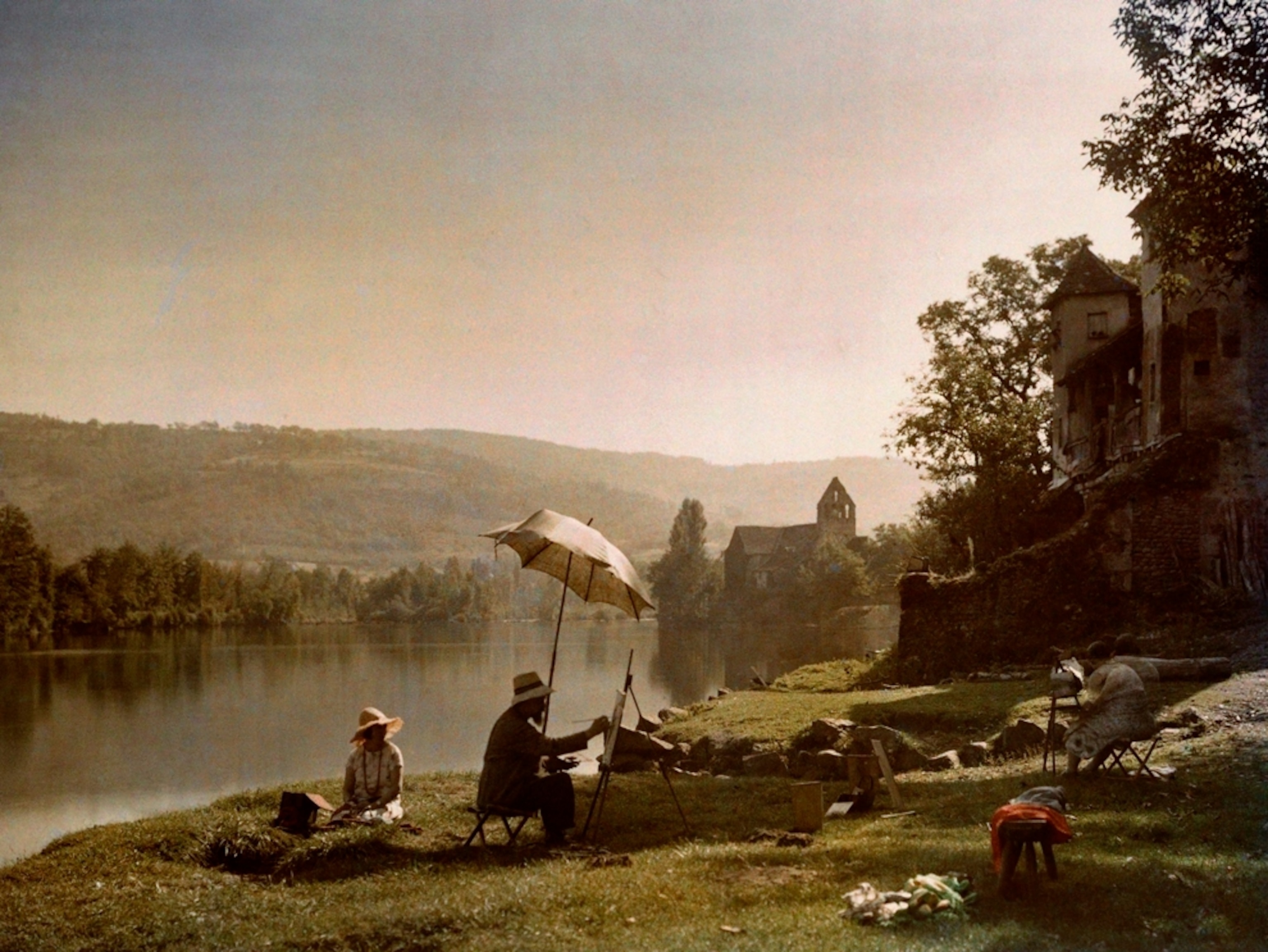 Artists painting on a riverbank