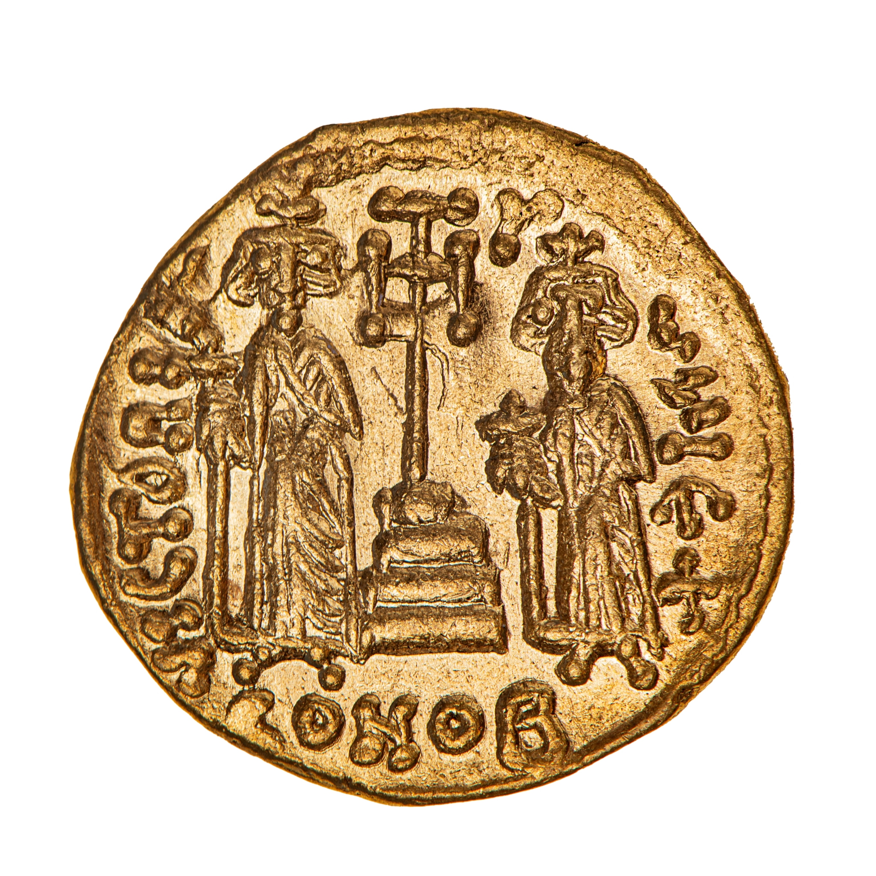 A round, gold coin with a stamped image of two figures and various symbols surrounding them.
