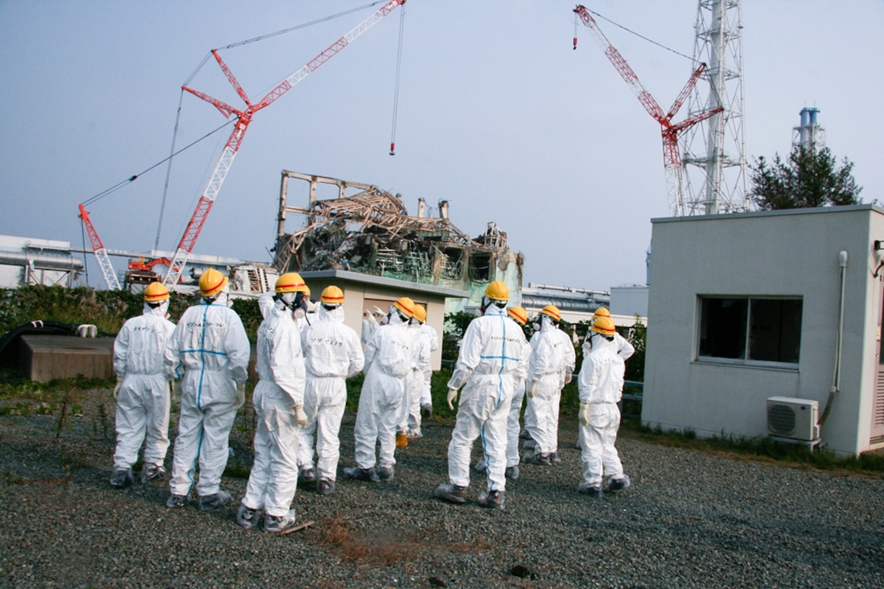 Nuclear experts dressed in protective gear outside Fukushima Daiichi