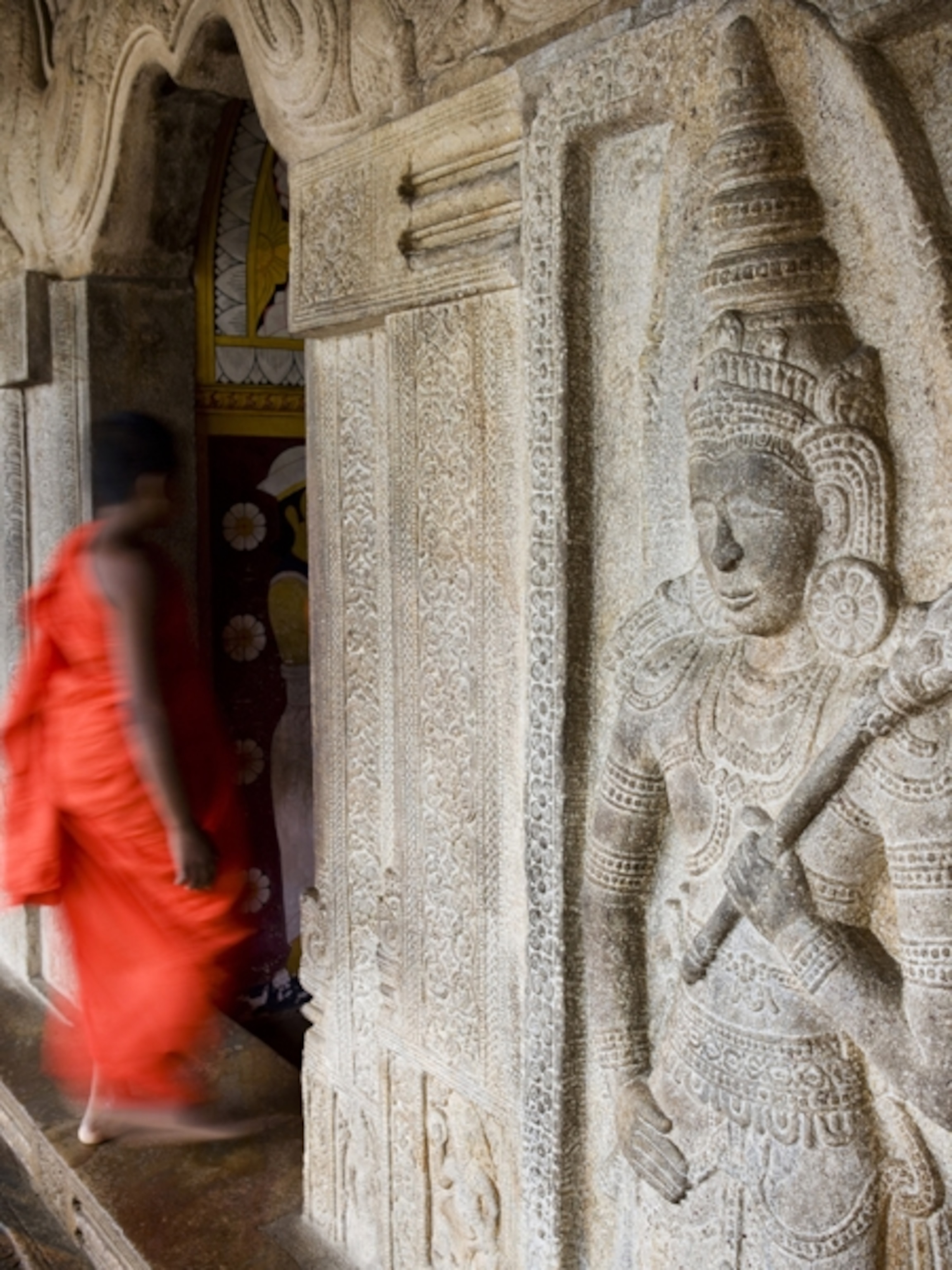 Monk entering temple wearing orange