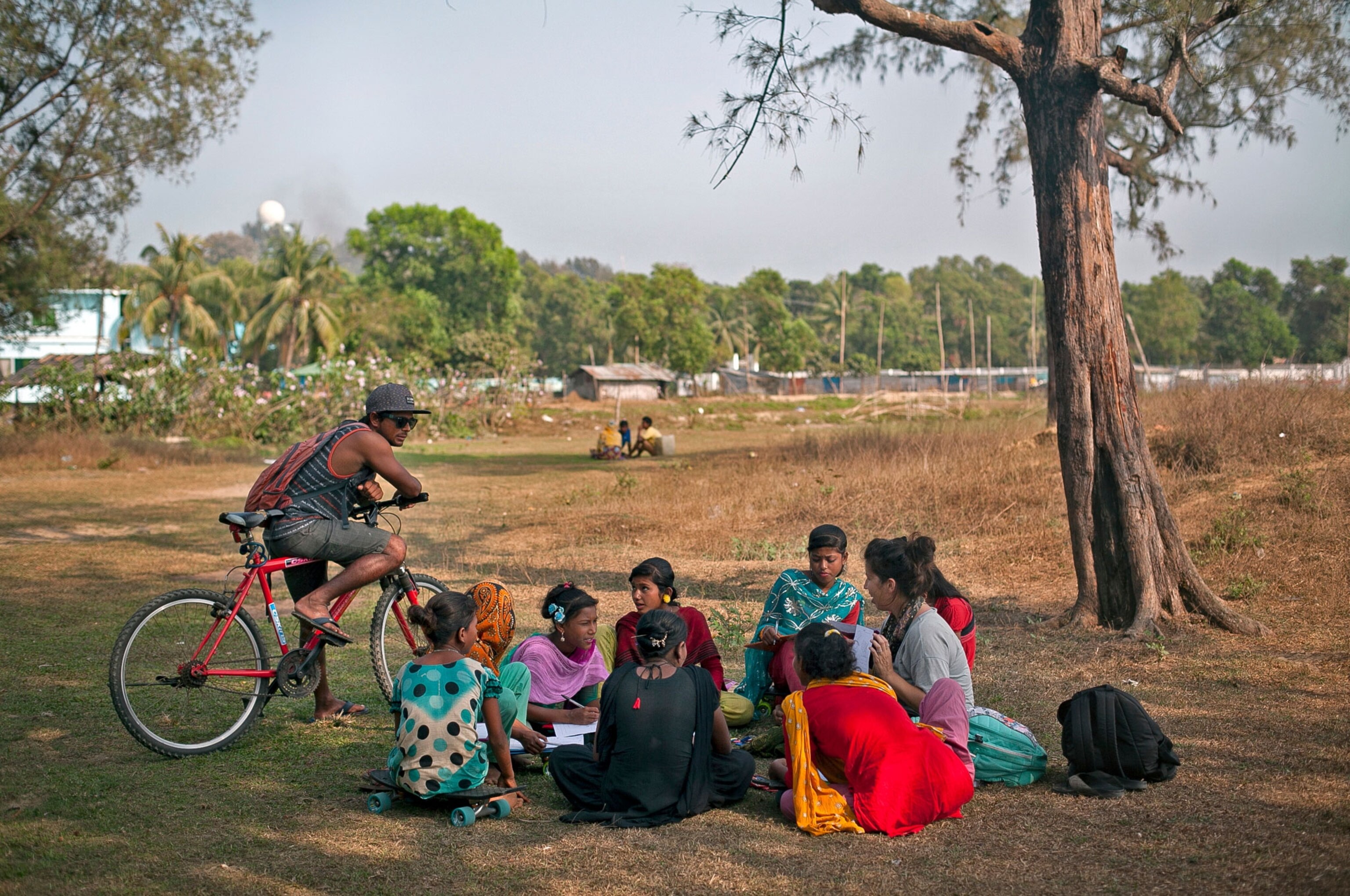 Rashed Alam, the leader of the Cox's Bazar Surf Club, watches as his wife, Venessa Rude, tutors the surf girls in a park near the beach.