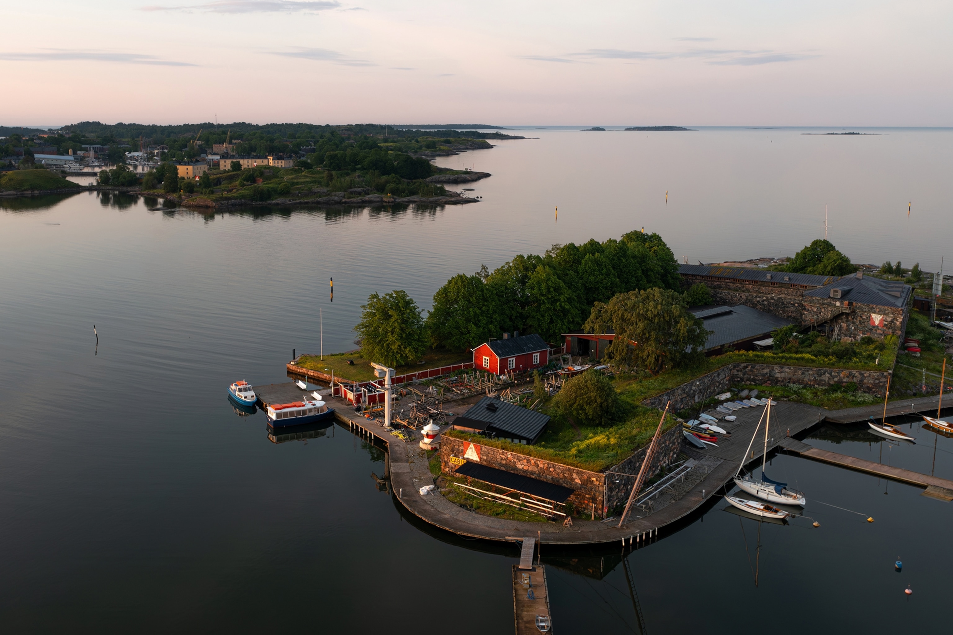 An aerial shot of an island in the middle of the gulf of Finland with boats dotted around the edge.