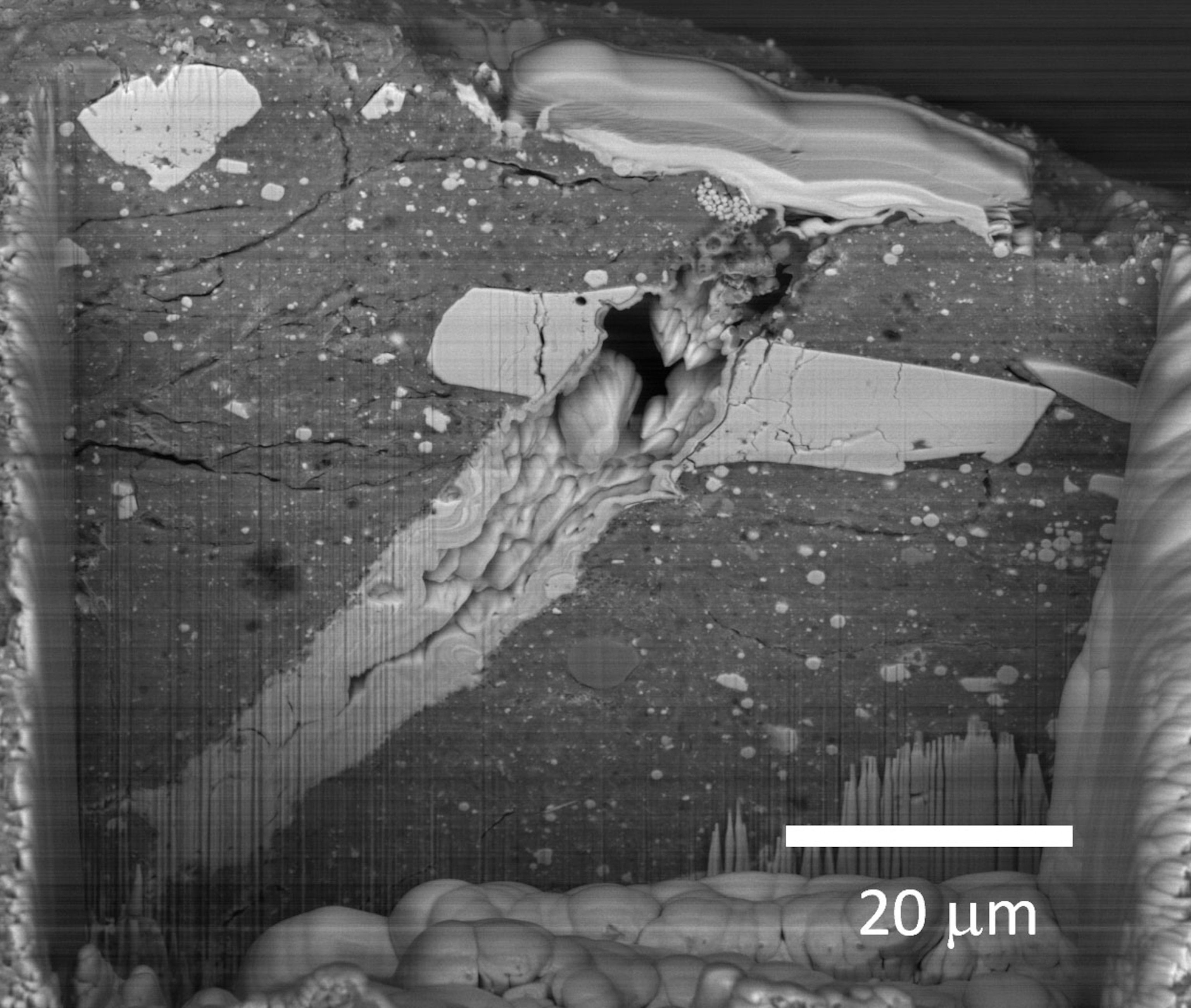 A scanning electron microscope image of a micrometeorite impact crater in a particle of asteroid Bennu material