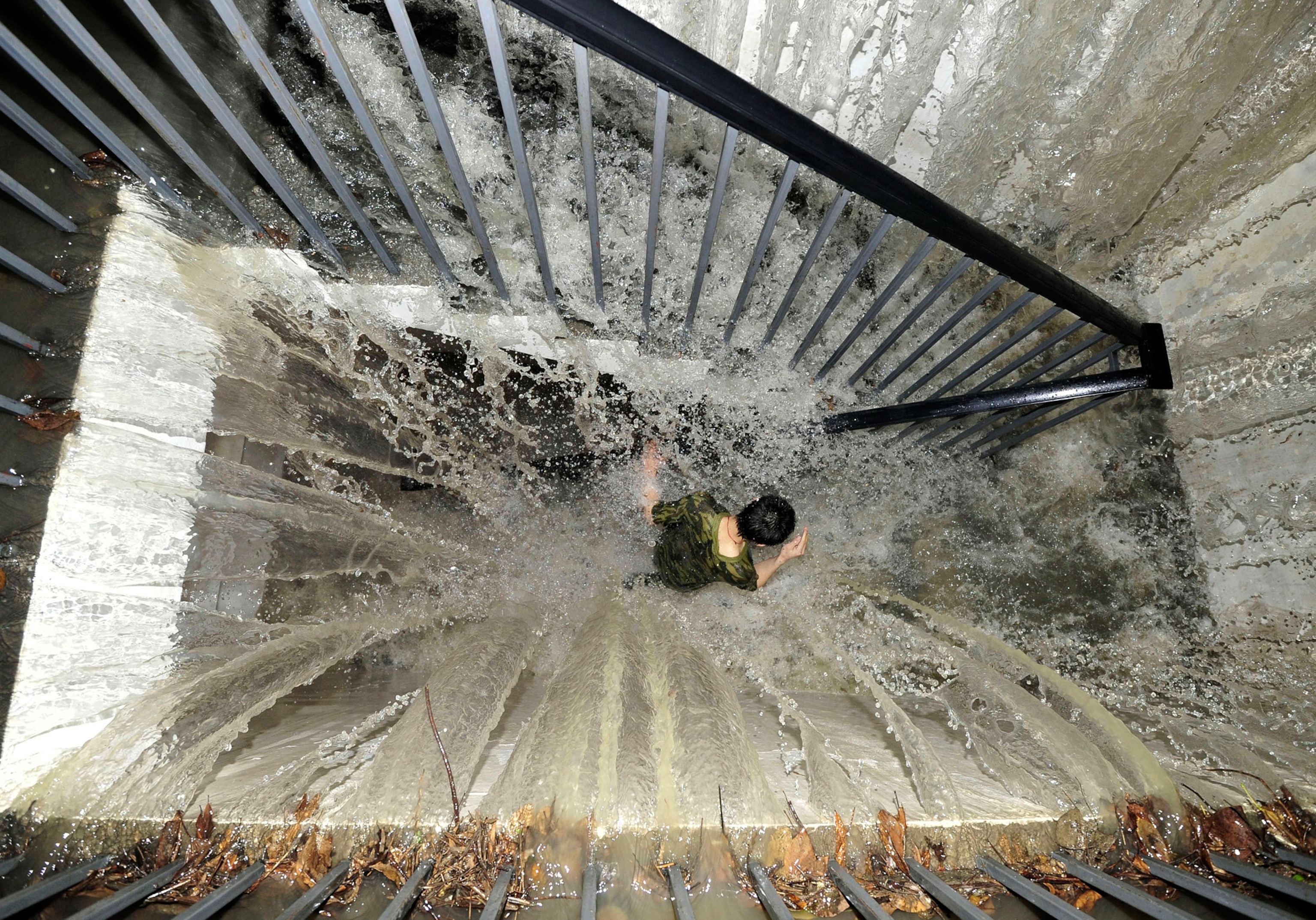 A resident runs on a flooded stairway as floodwater pours into an underground garage amid heavy rainfalls in Chengdu, China.
