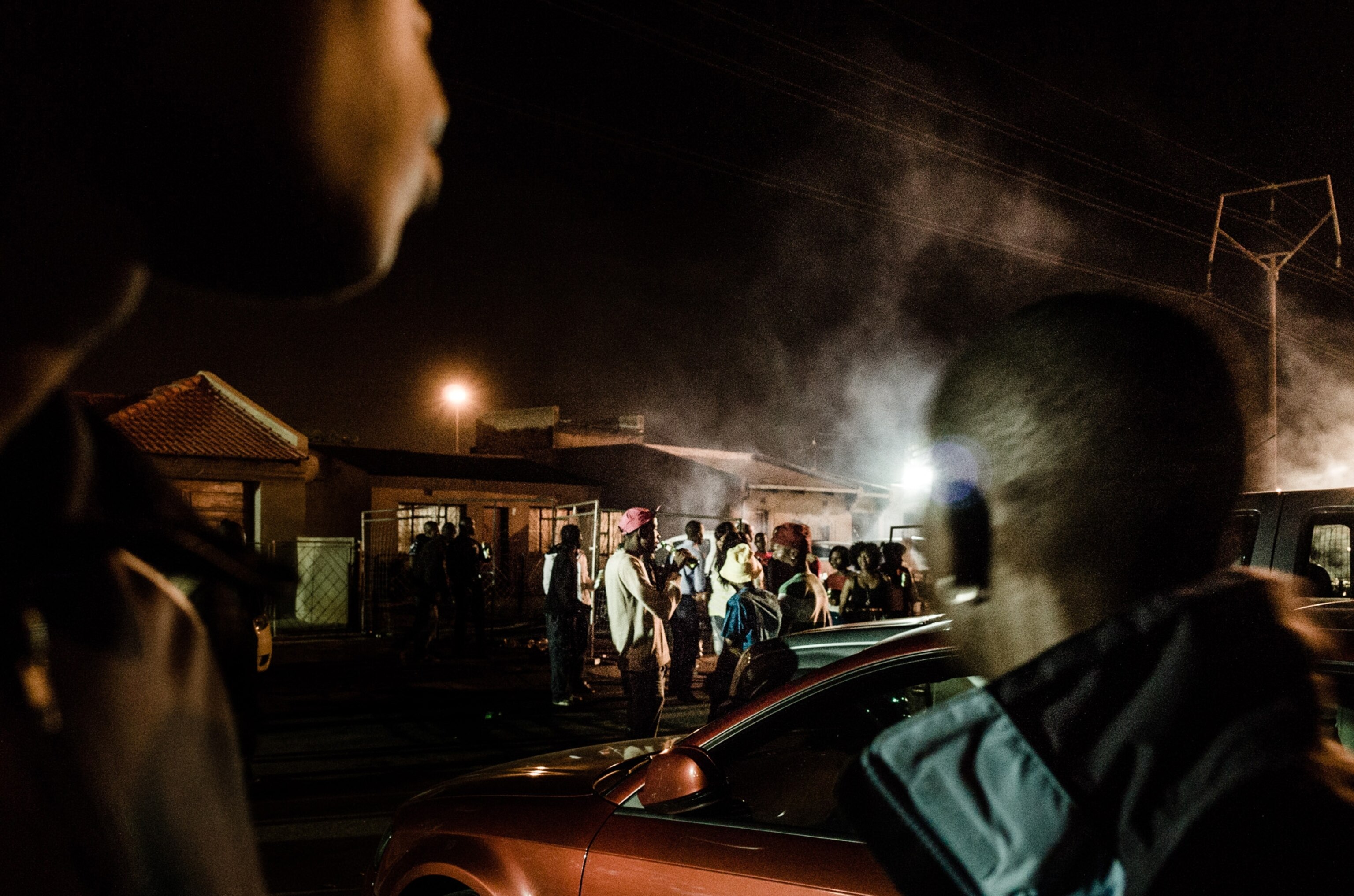 A crowd of people hanging out in the street in Kwesine, Jannesburg.