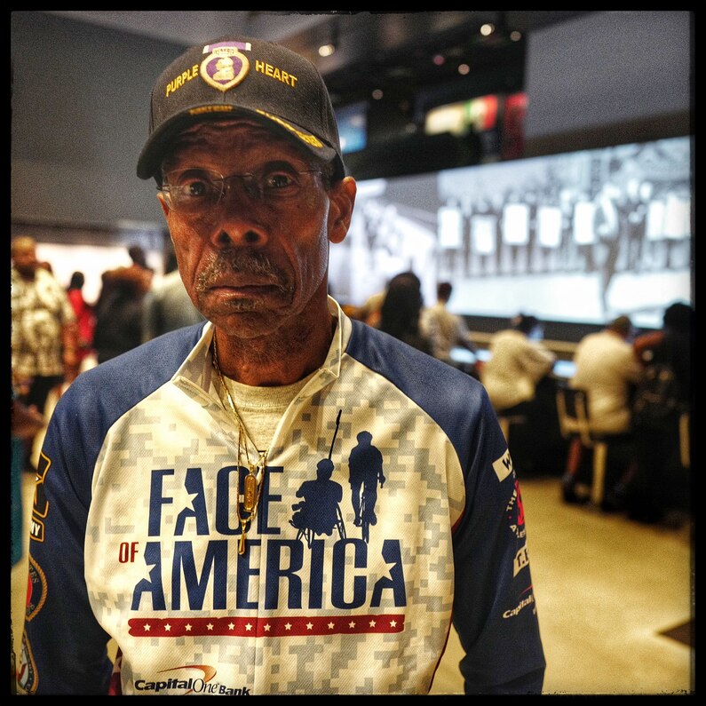 A gentleman walks through the floor of the museum where the art focuses on civil unrest.