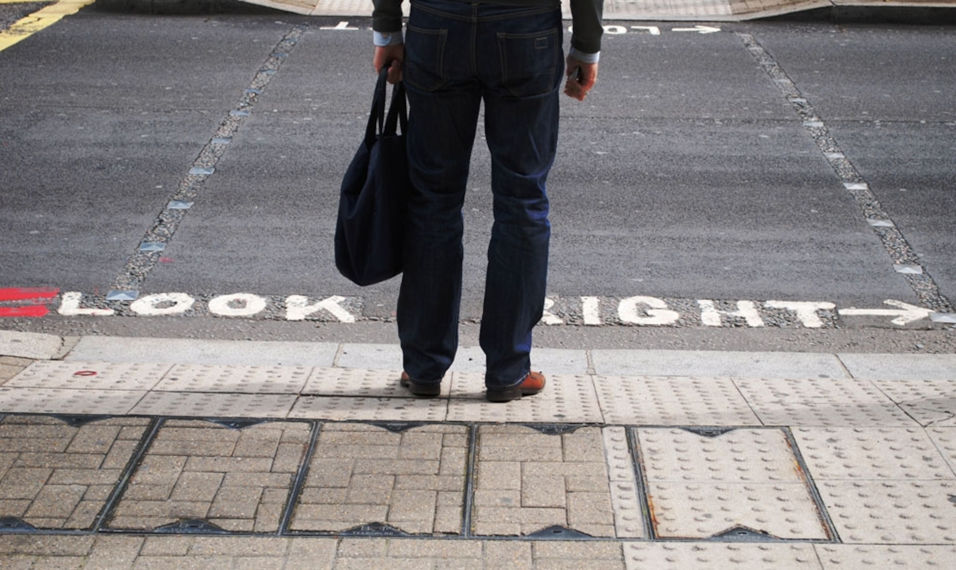 A man standing at a crosswalk in London