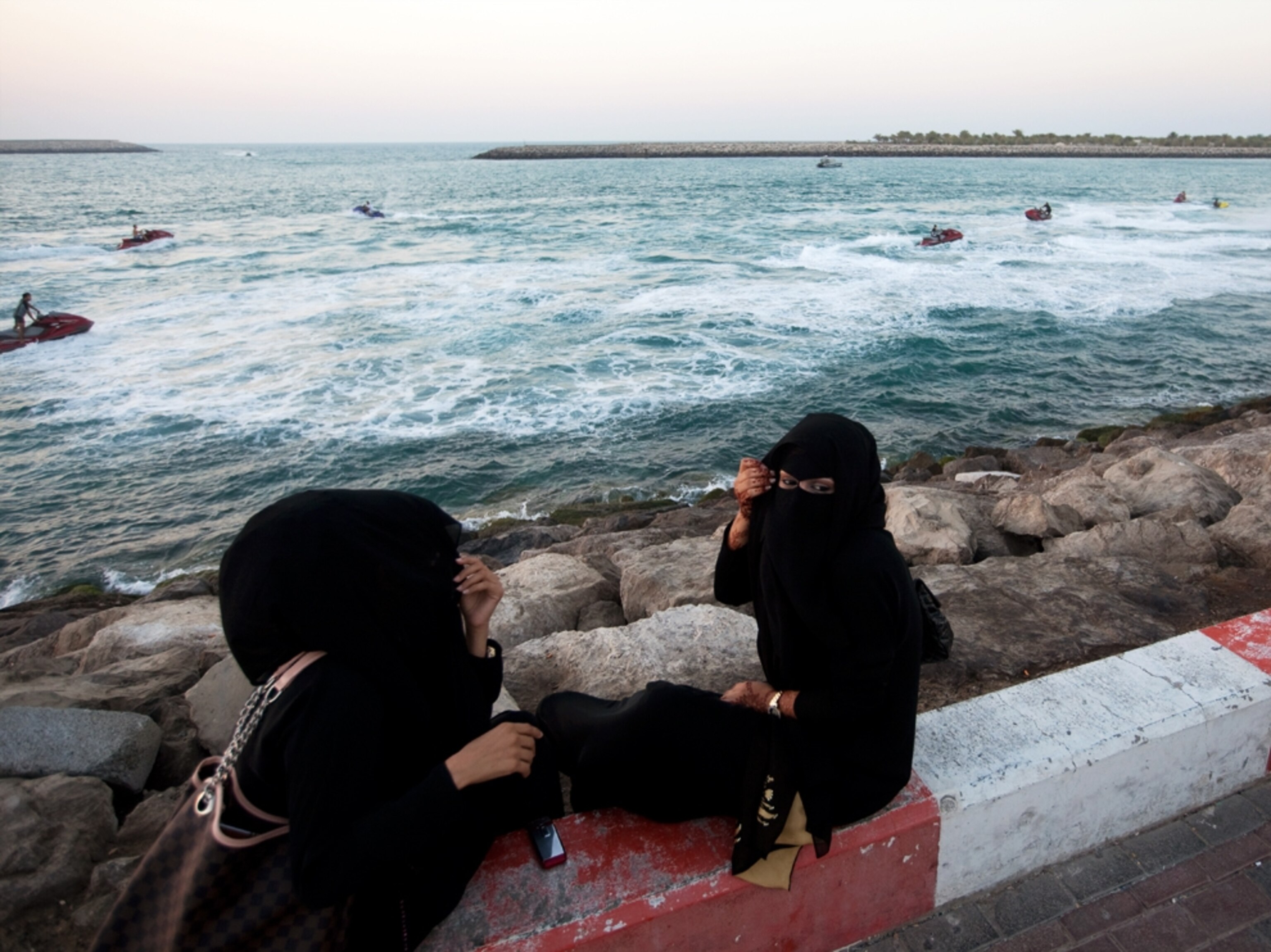 Muslim women talking along waterfront (photo)