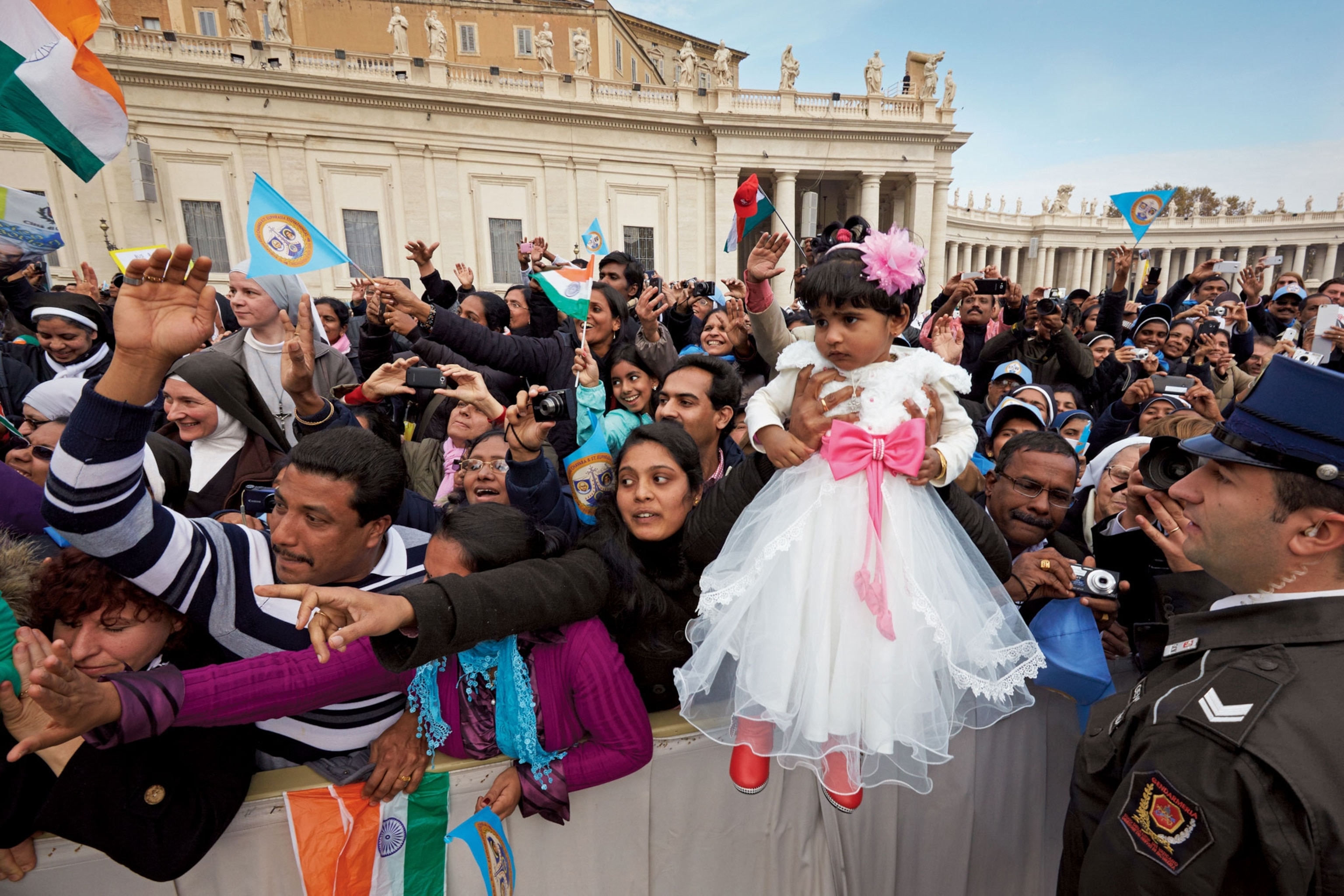 parents holding their daughter to see the Pope