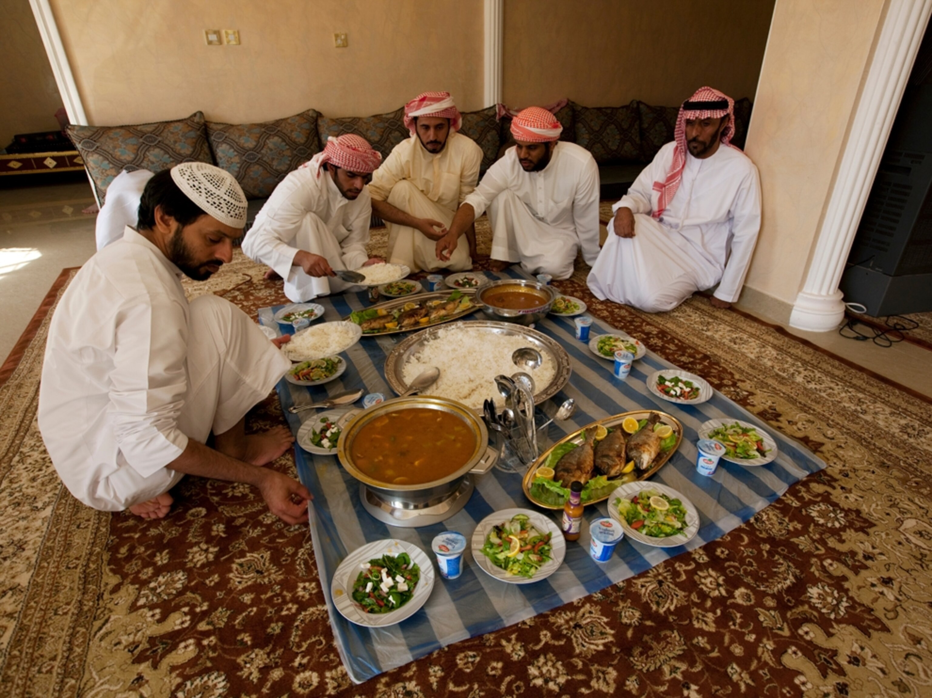Men sit and eat a traditional meal