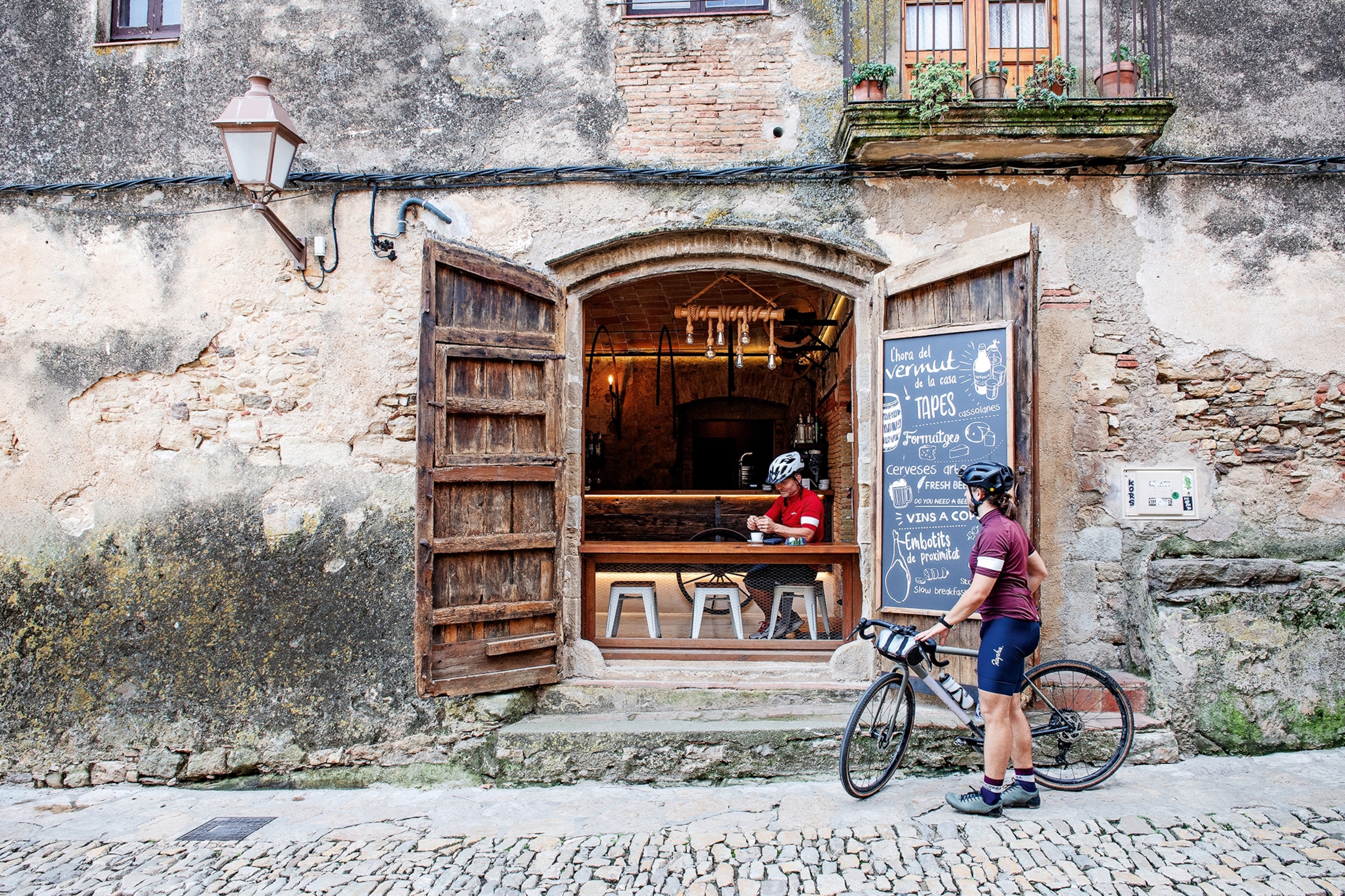 Cyclist outside cafe in Peratallada.