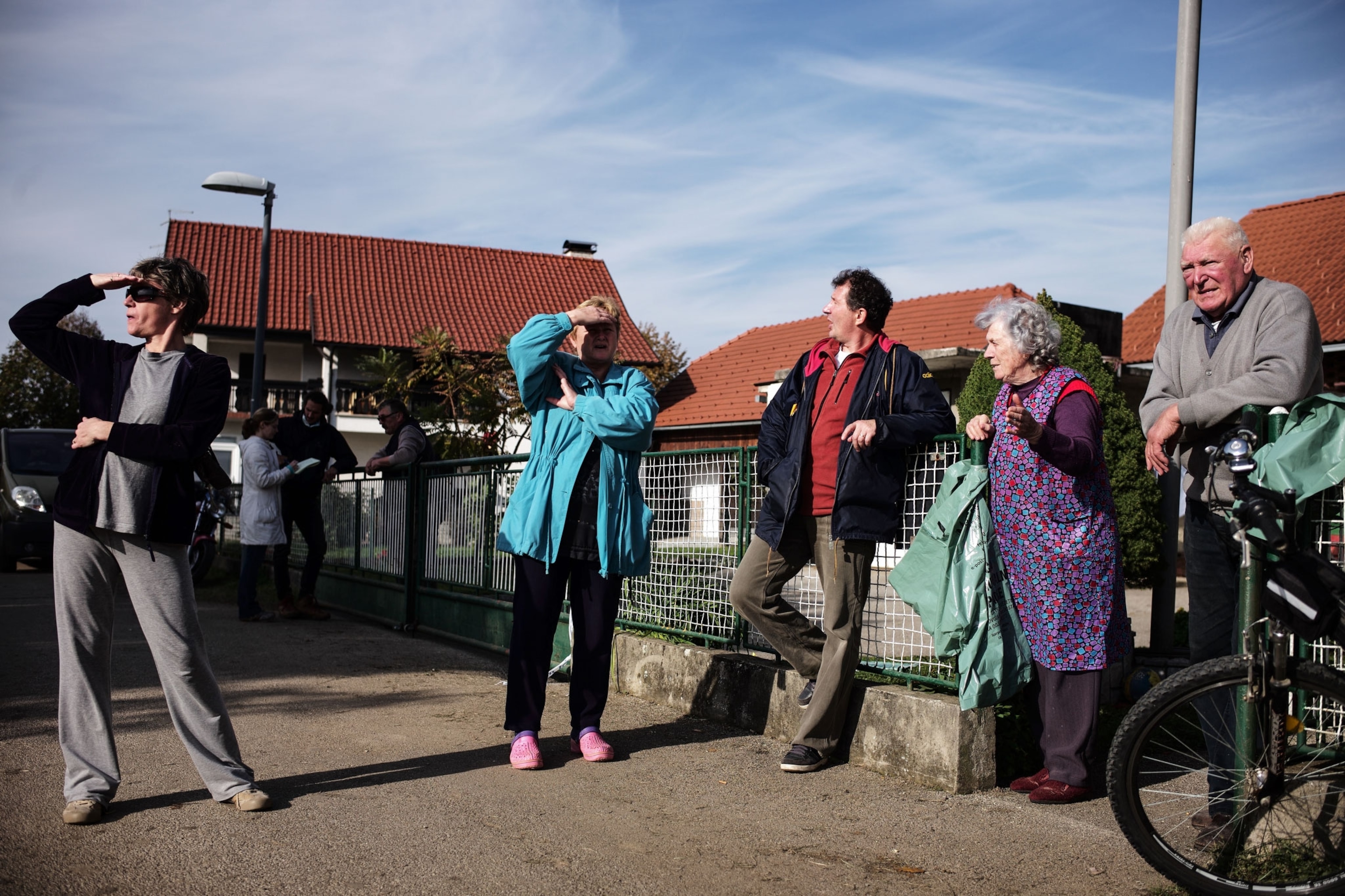 locals watching refugees walk by in Rignoce, Slovenia
