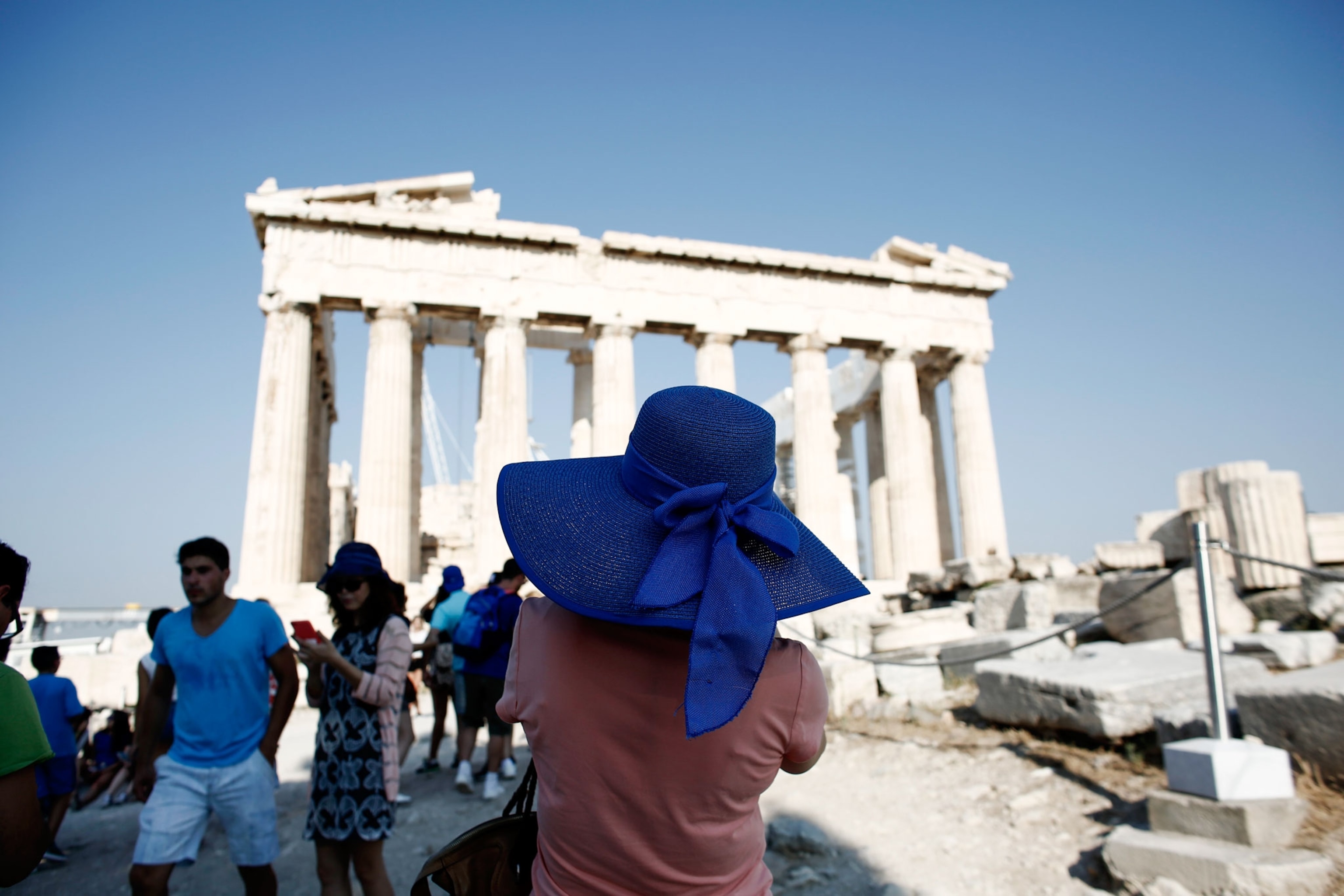 a woman taking a picture of the Acropolis