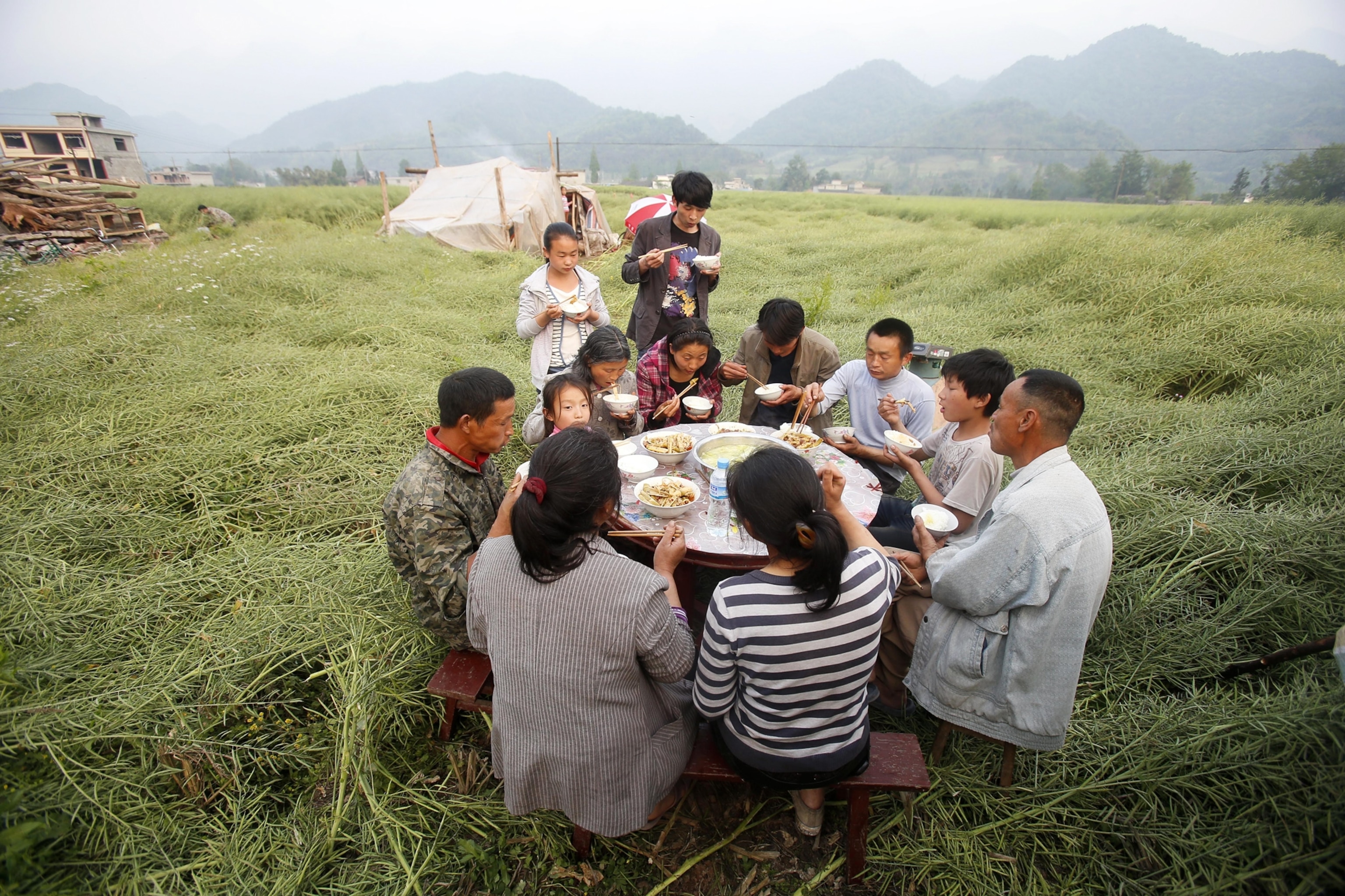 a family eating outdoors after an earthquake, Sichuan Province, China