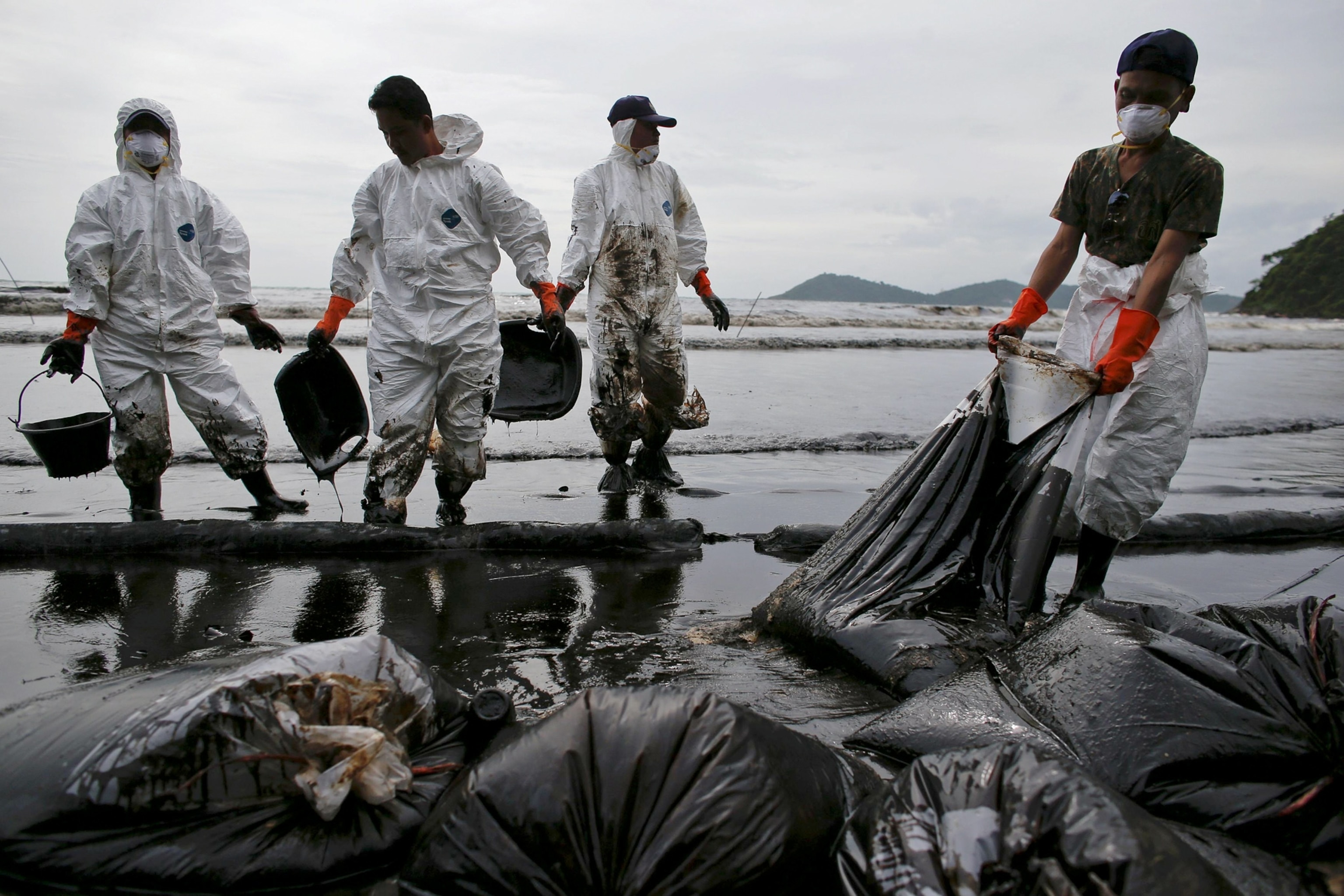 Members of the Thai military carry sand and cleanup waste off the beach on Samet Island.