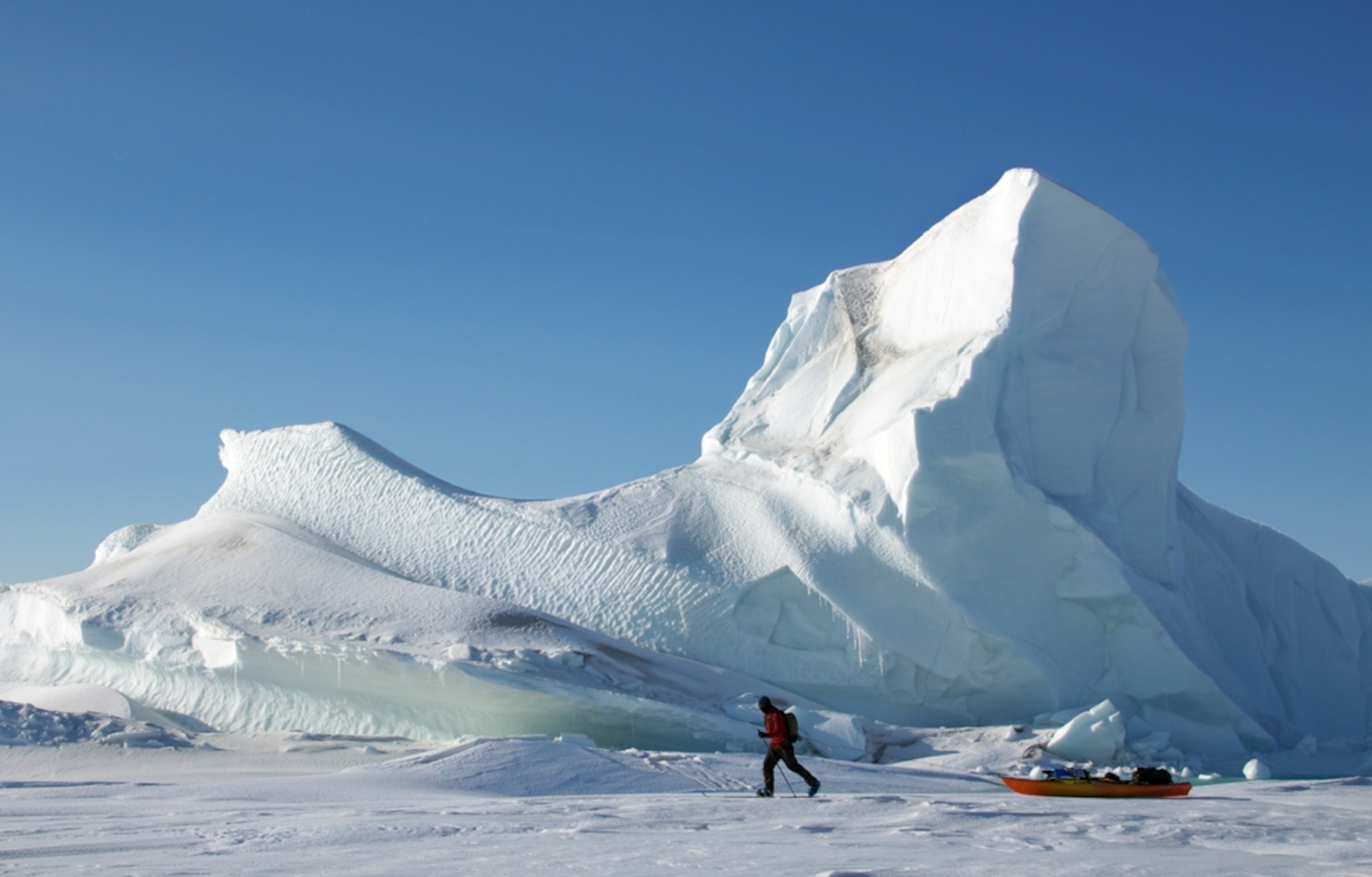 Man pulls a kayak along ice in British Columbia