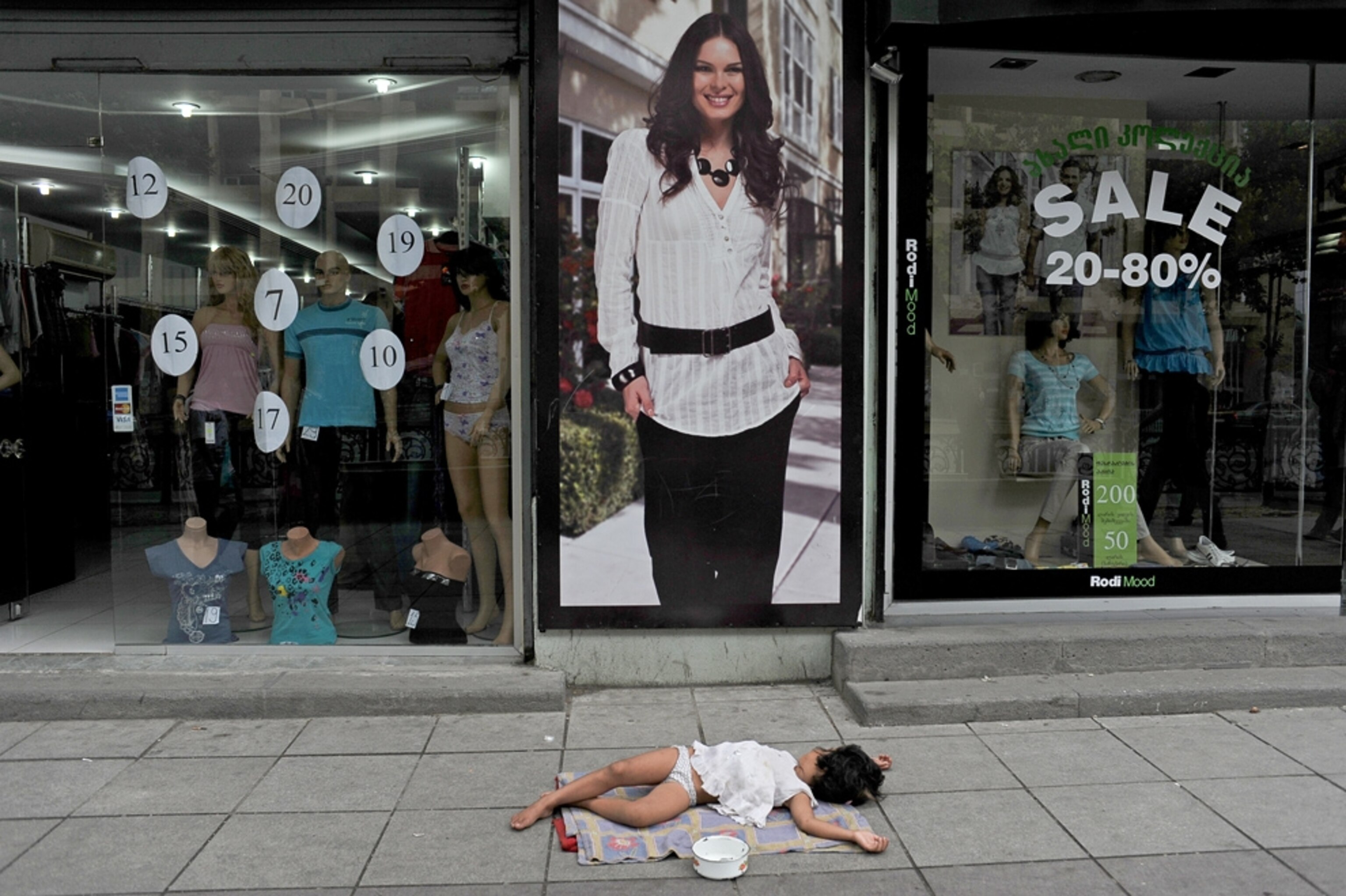 A child beggar sleeps on the street in Tbilisi, Georgia